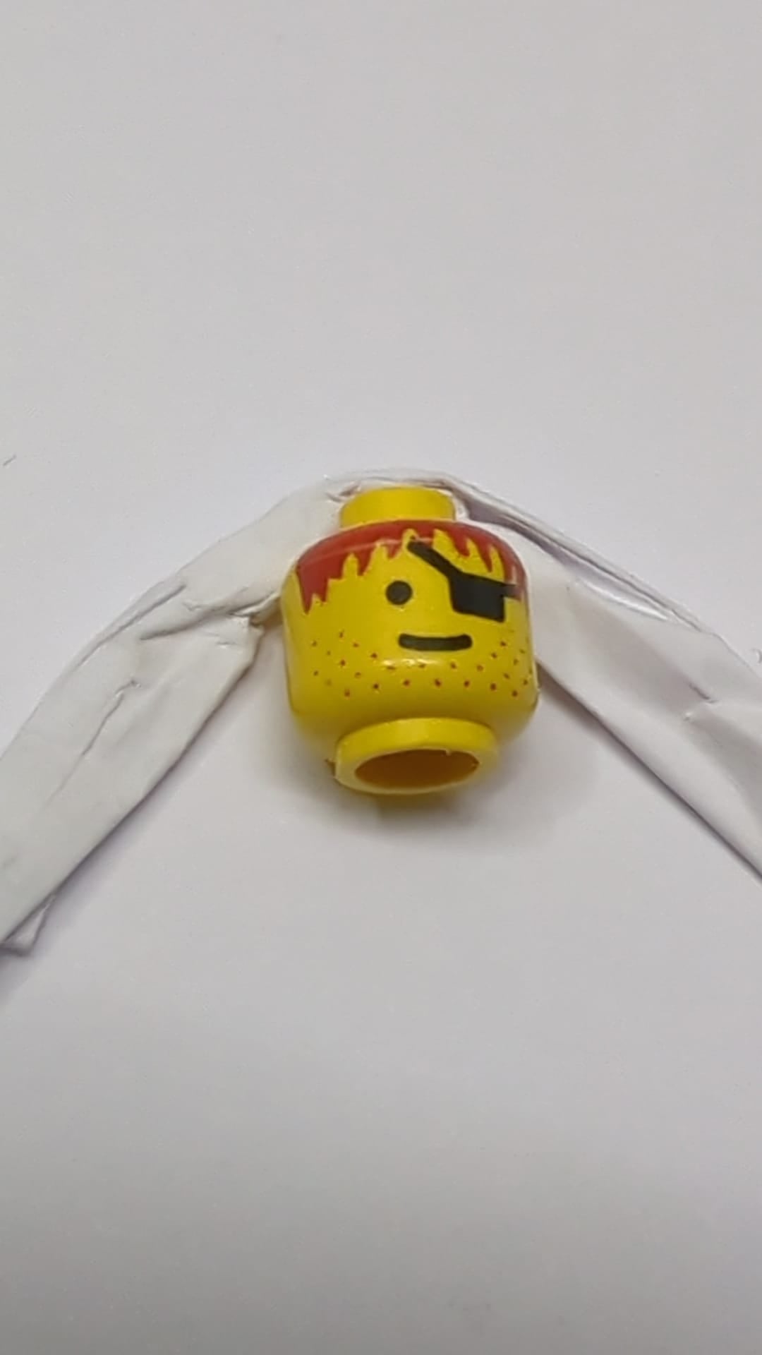 Minifigur, männlicher Kopf mit Augenklappe, Stoppelbart, rotbraunes Haarmuster gelb