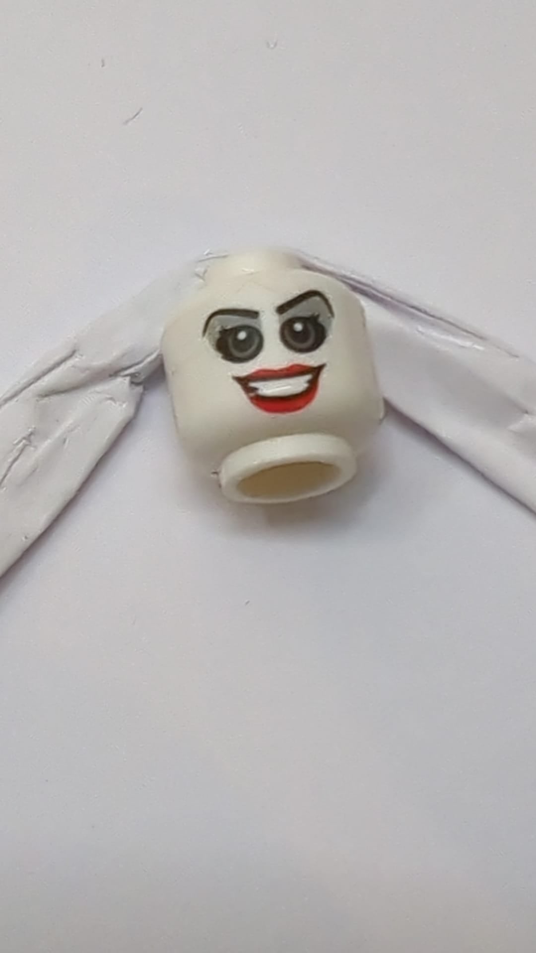 Minifigur, Kopf doppelseitig, weiblich, graue Augen und Lidschatten, rote Lippen, offenes Lächeln / entblößte Zähne, wütendes Muster "Harley Quinn" weiß