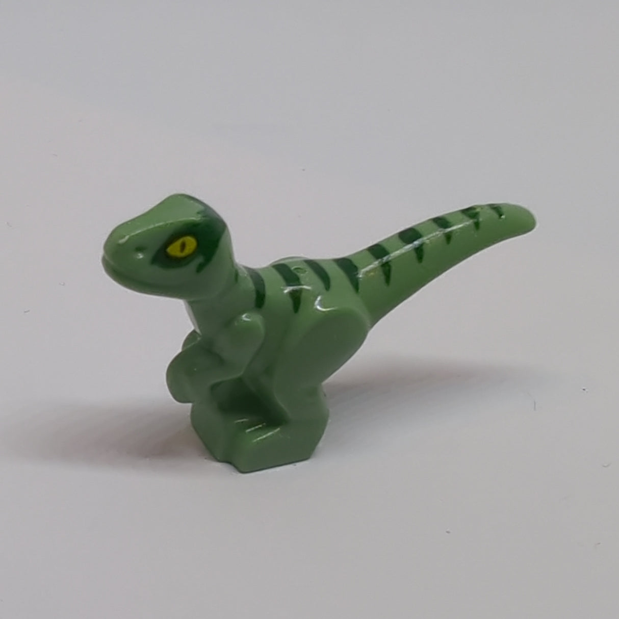 Dinosaur Baby Standing with Dark Green Stripes and Yellow Eyes Pattern (Jurassic World Delta) sandgrün sand green