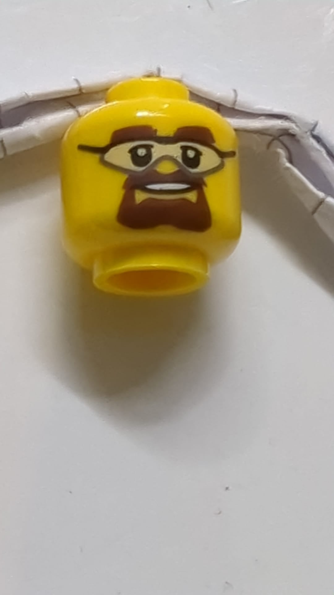 Minifigur, Kopf mit Schutzbrille, braunen Augenbrauen und Spitzbartmuster gelb