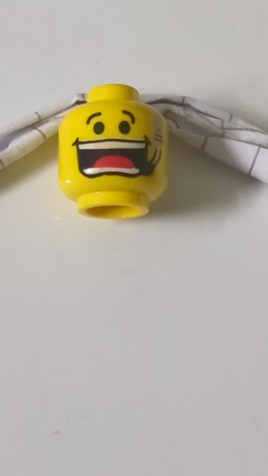 Minifigur, Kopf mit schwarzen Augenbrauen, Headset mit Mikrofon, breites, offenes Lächeln mit leicht geöffneten Zähnen und rotem Zungenmuster gelb