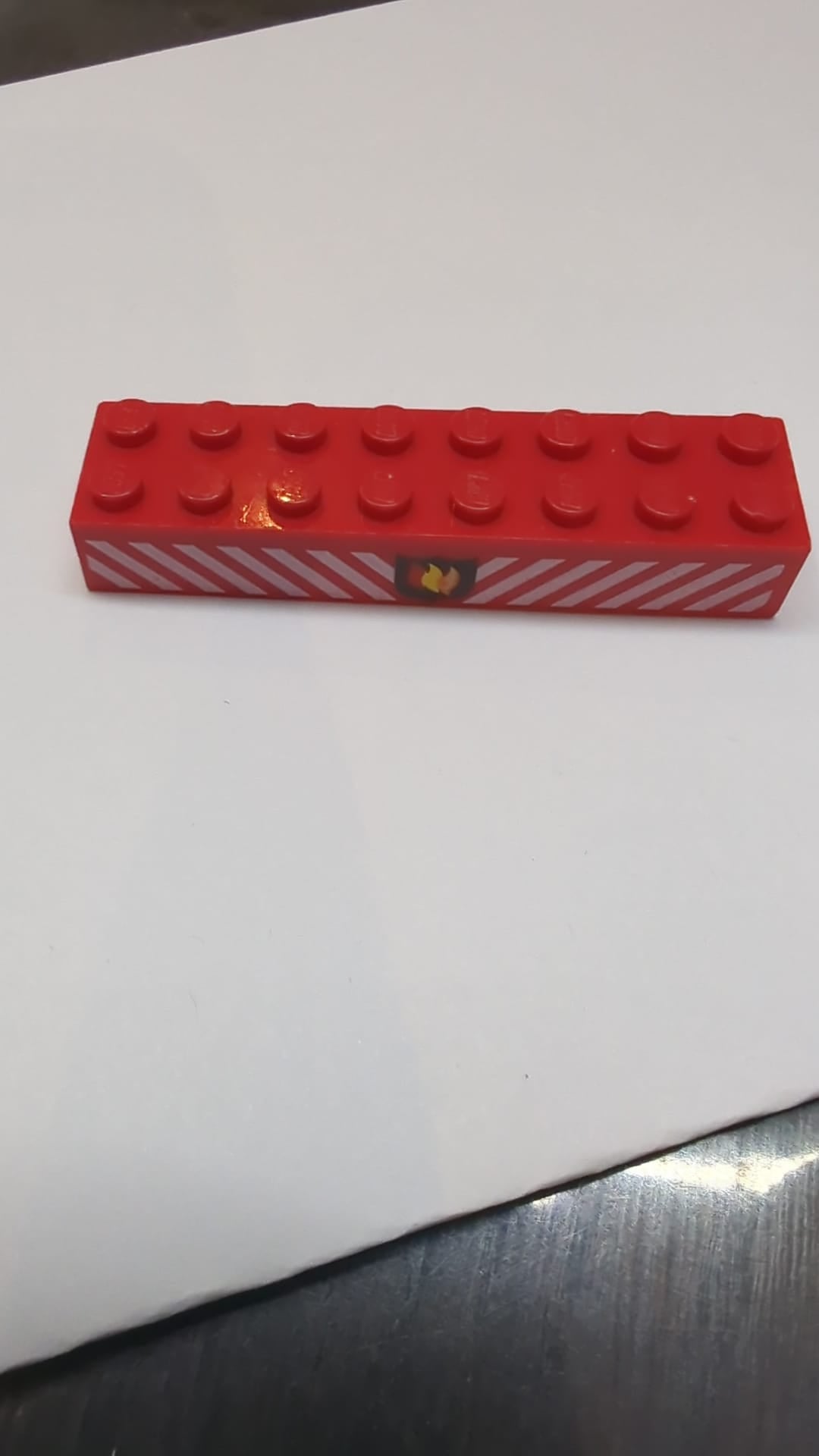 2x8 Ziegelstein mit Feuerwehr-Logo und weißem Gefahrenstreifenmuster rot