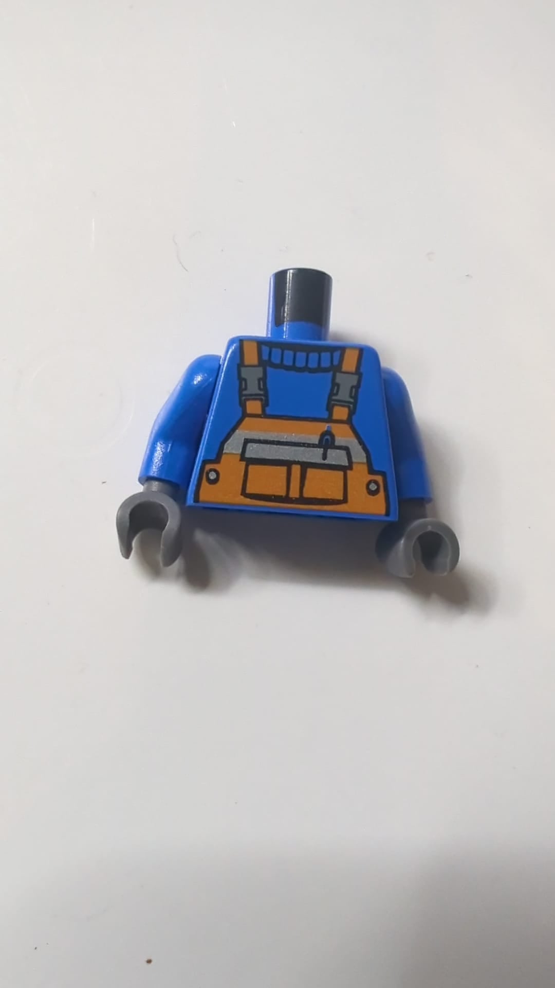 Oranger Overall mit Stift in der Tasche und reflektierendem Streifenmuster am Hemd / blaue Arme / dunkelblaugraue Hände blau