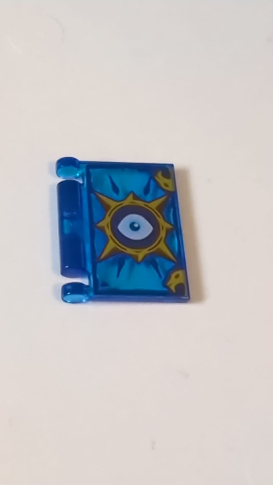 Minifigur, Utensil Buchumschlag mit goldenem Kreis mit Stacheln, weißem Auge, dunkelblauem Akzentmuster „Nexo Knights Buch der Angst“ transparent dunkelblau