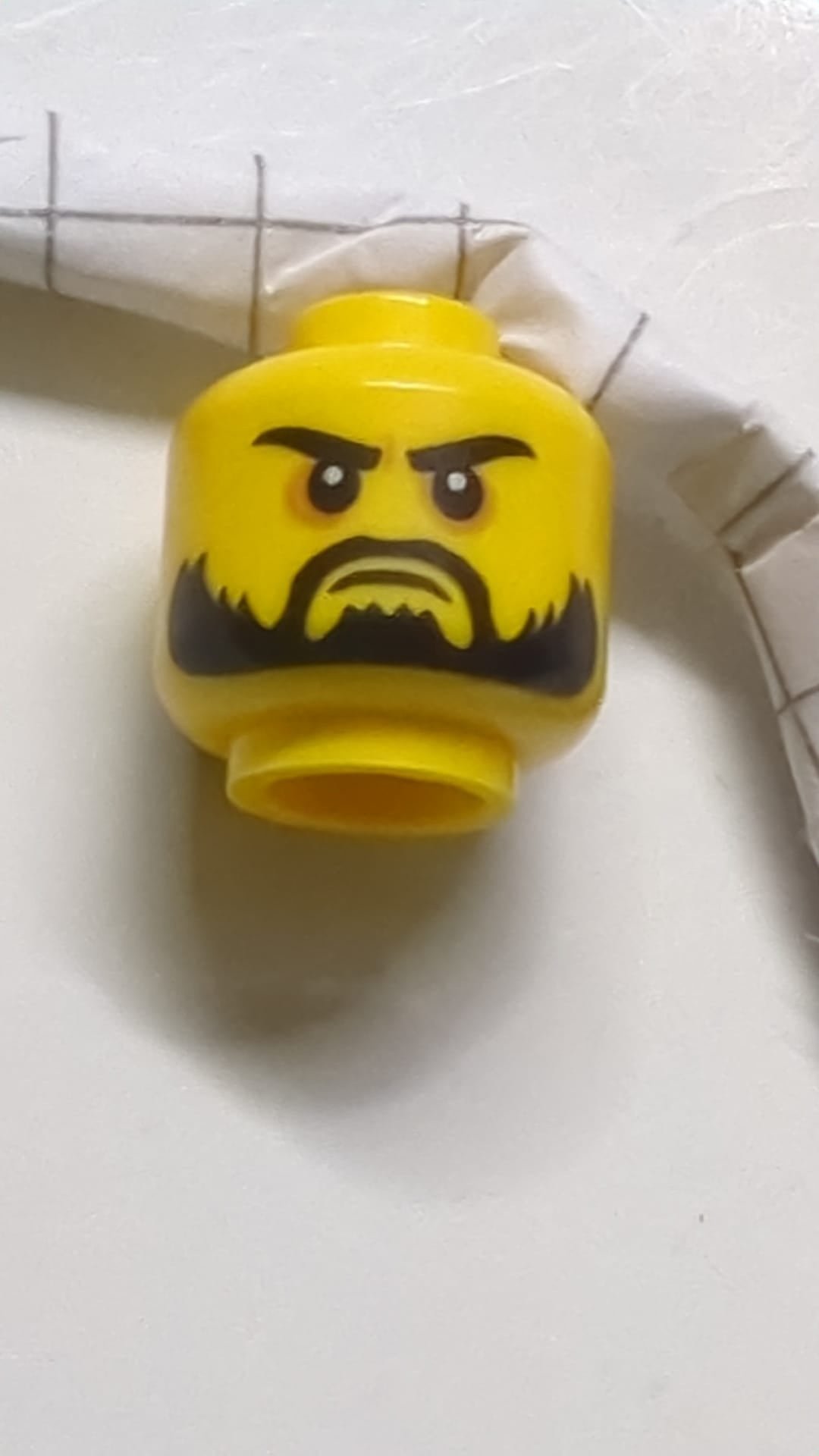 Minifigur, Kopf mit doppelseitigem Bart, schwarze Augenbrauen, fester/wütender Mund gelb