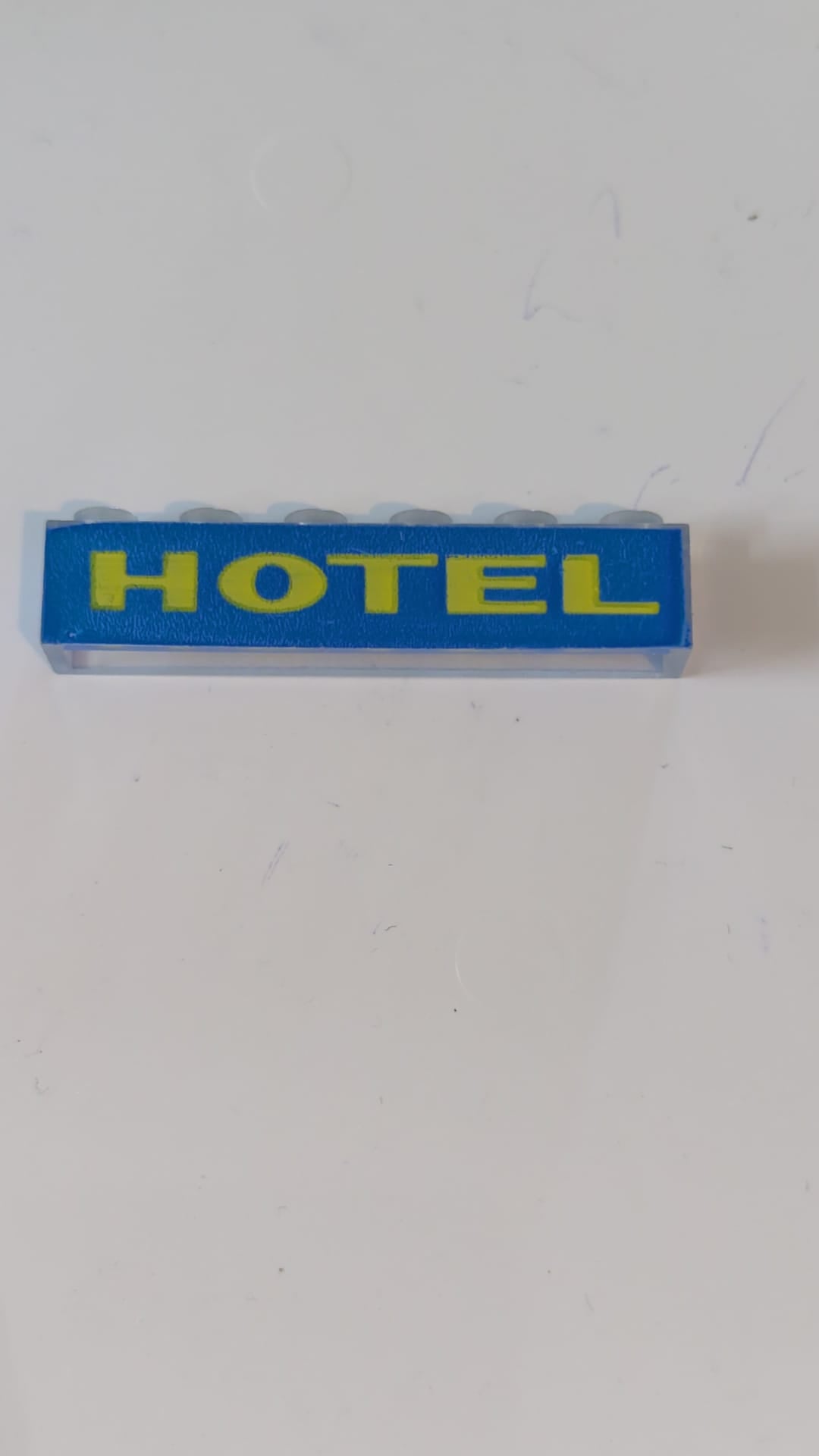 1x6 Stein ohne Bodenrohre mit gelbem „HOTEL“ auf blauem Hintergrundmuster transparent weiß