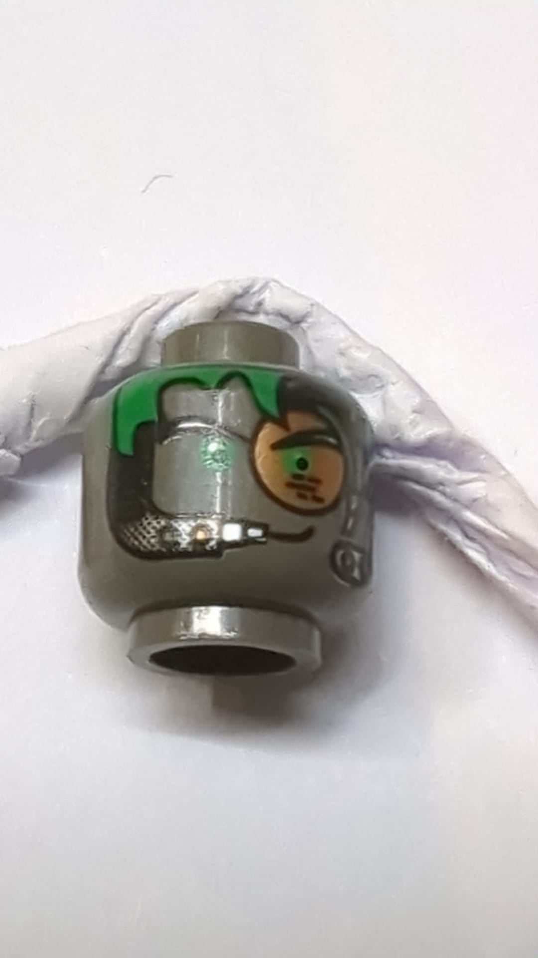 Minifigur, Alienkopf mit grünen Haaren, kupferfarbenem Okular und Headset-Muster dunkelgrau