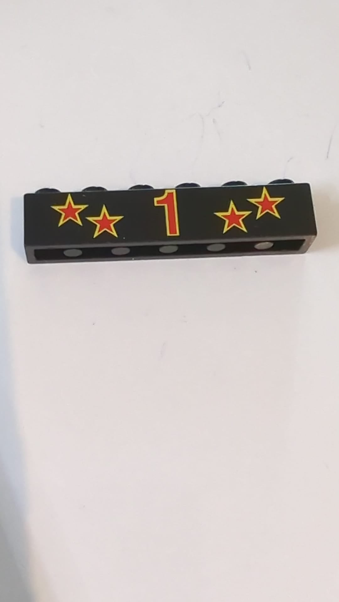 1x6 Stein mit roter Zahl 1 und Sternen mit gelbem Randmuster schwarz