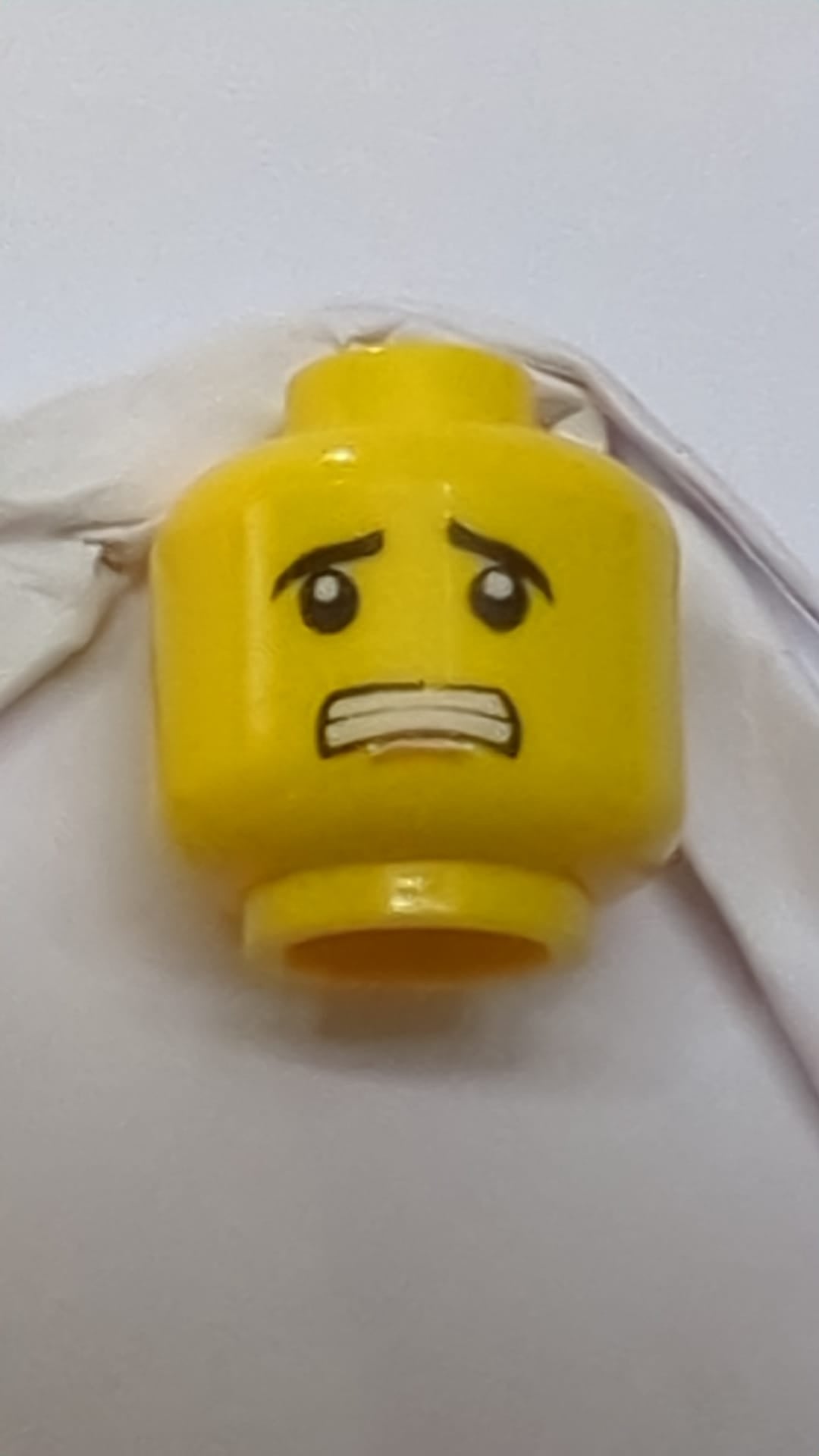 Minifigur, Kopf mit doppelseitigen schwarzen Augenbrauen, mittelgroßes nougatfarbenes Kinngrübchen, schmales Grinsen/ängstlicher, offener Mund mit Zahnmuster gelb