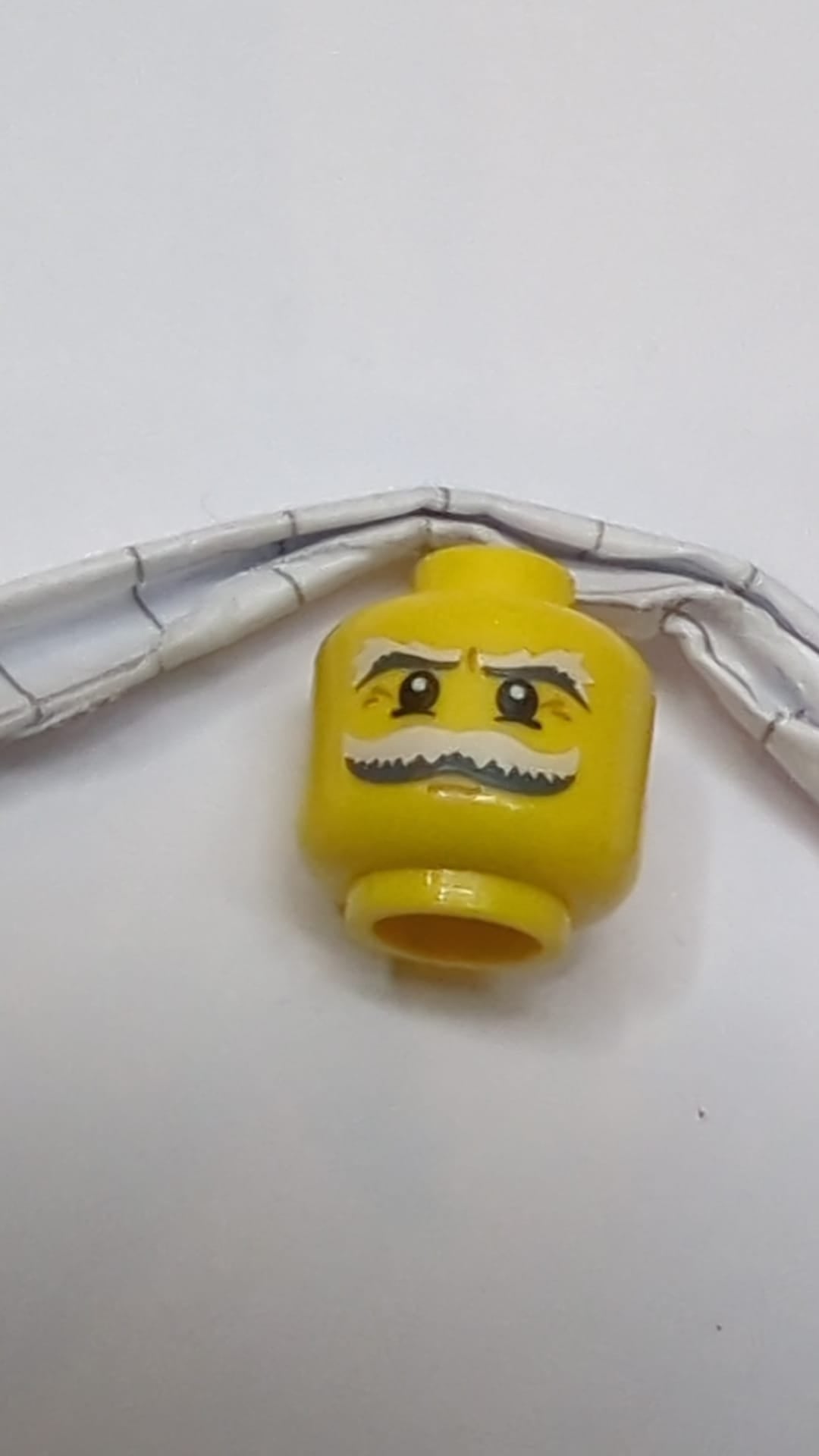Minifigur, Kopf, Schnurrbart und Augenbrauen, weiß und dunkelblaugrau, buschig, weiße Pupillen und Krähenfüße-Muster gelb