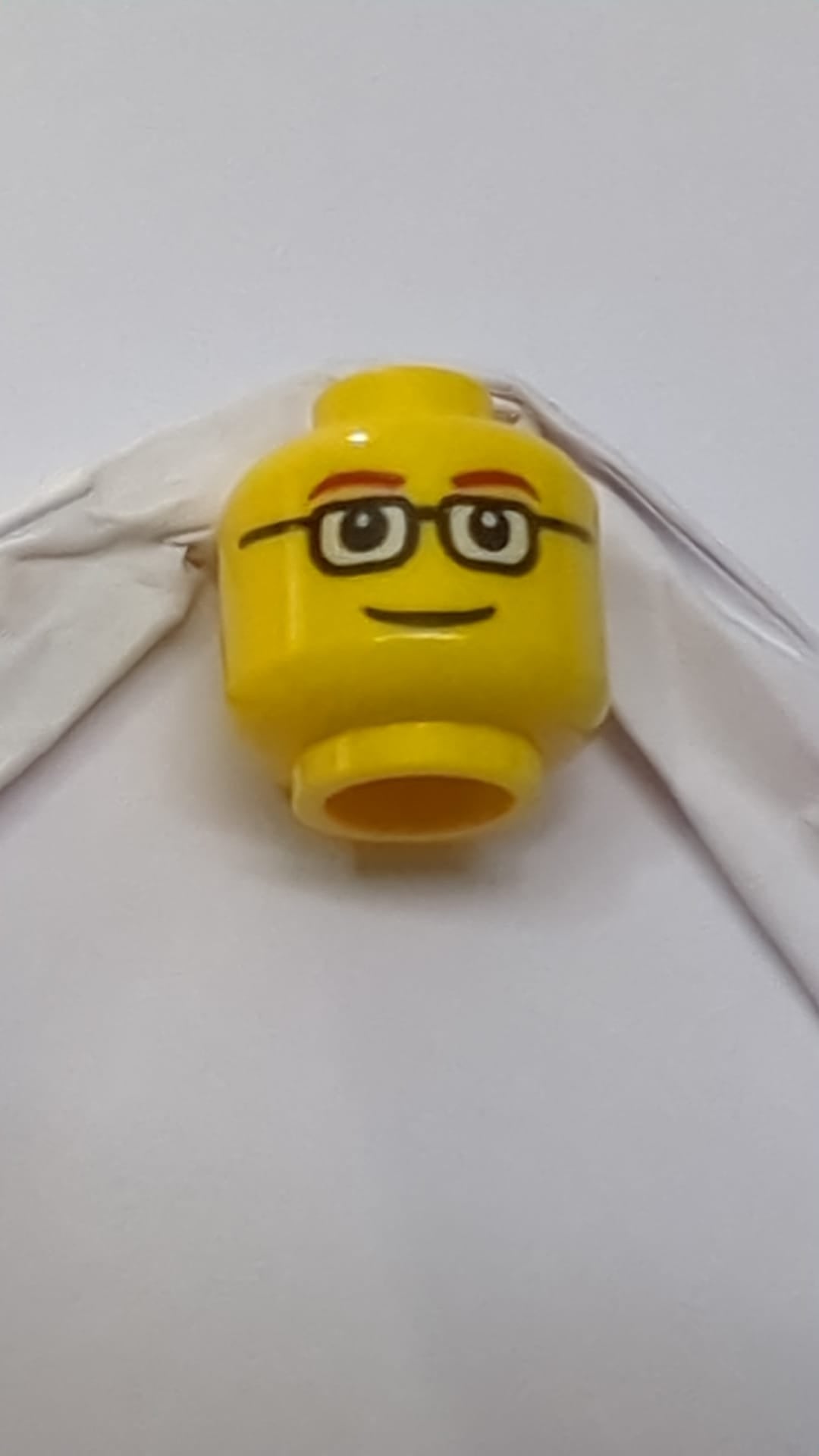 Minifigur, Kopf: dunkelrote, dünne Augenbrauen, schwarze rechteckige Brille mit weißen Gläsern, Grinsen gelb