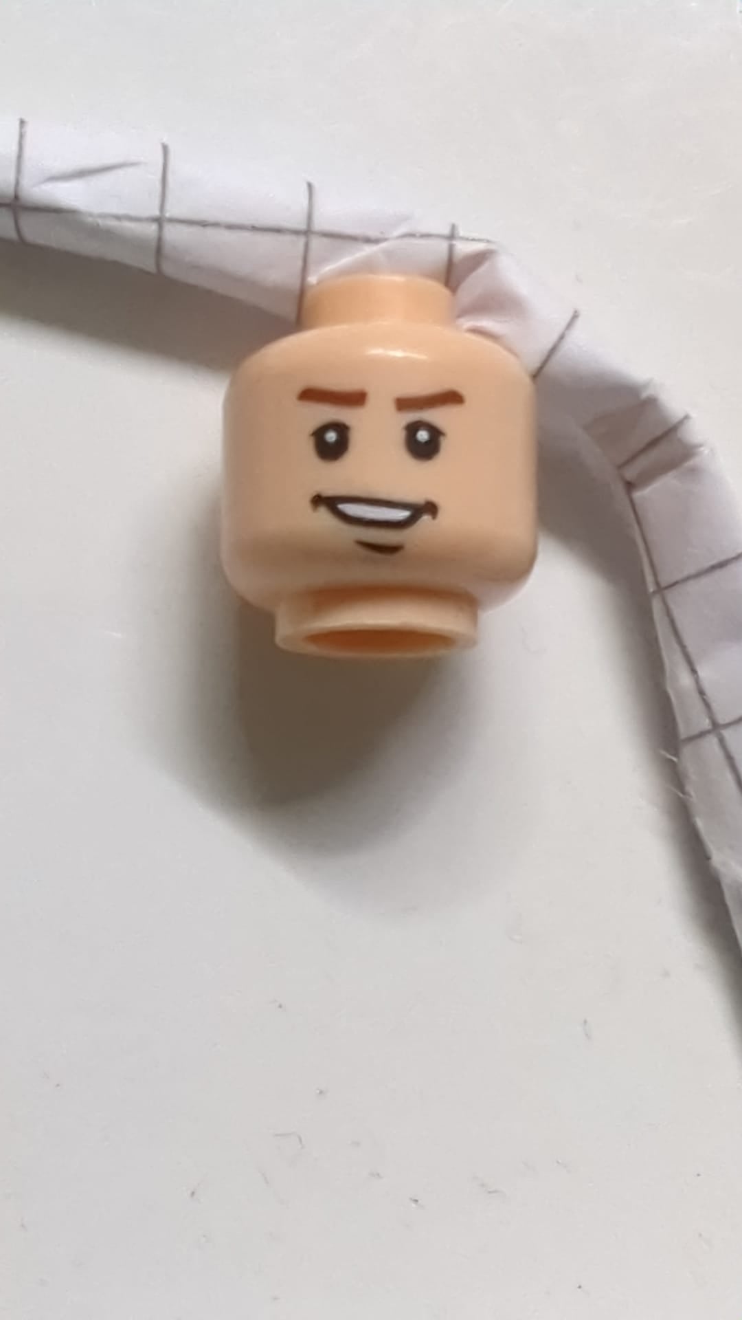 Minifigur, Kopf: rötlich-braune Augenbrauen, Oberlider, Grübchen und Kinngrübchen, asymmetrisches, offenes Lächeln mit Zahnmuster hellnougat (fleischfarben)