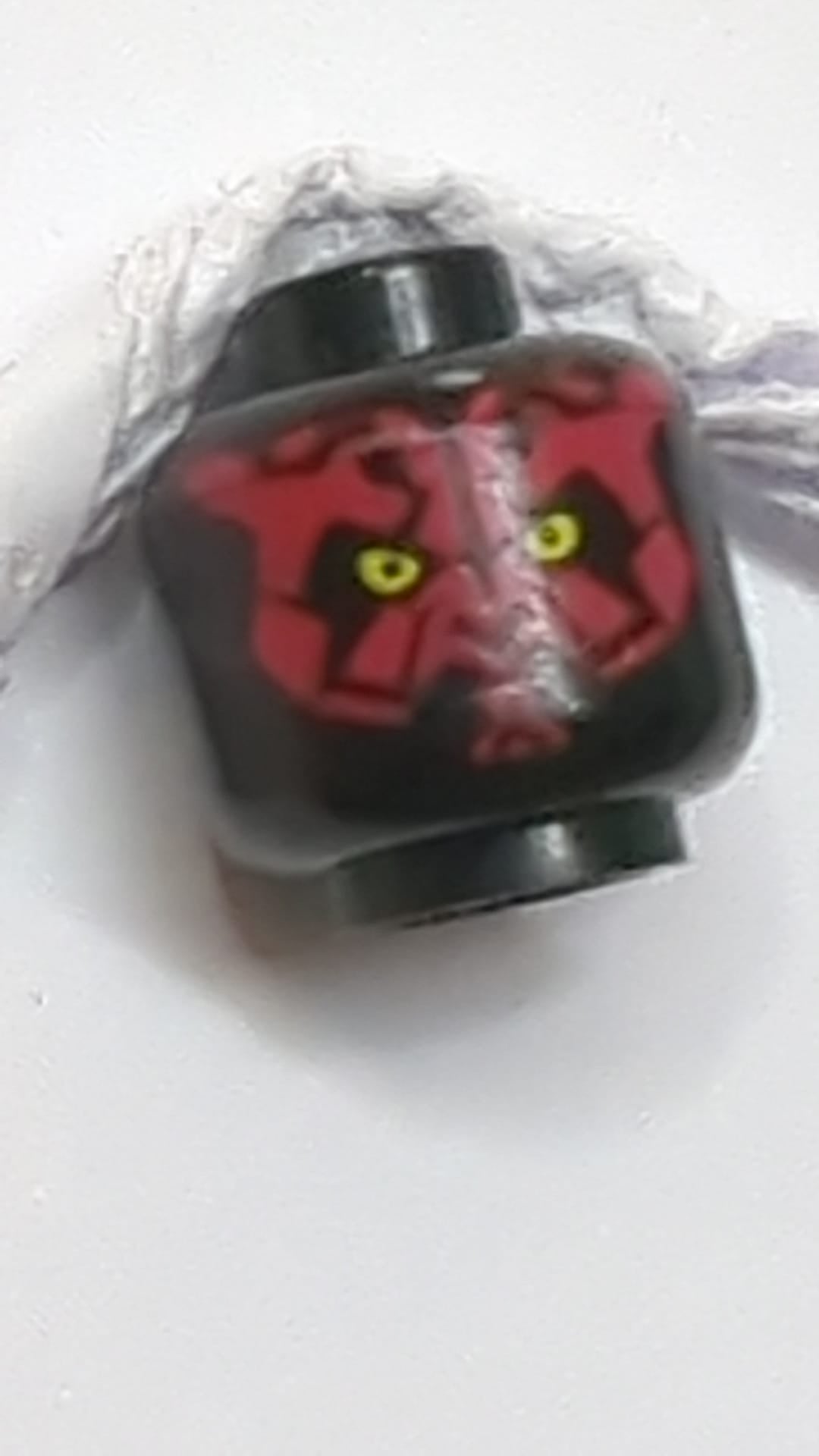 Minifigur, Alienkopf mit Star Wars Darth Maul-Motiv, rotes Gesicht, kleine gelbe Augen schwarz