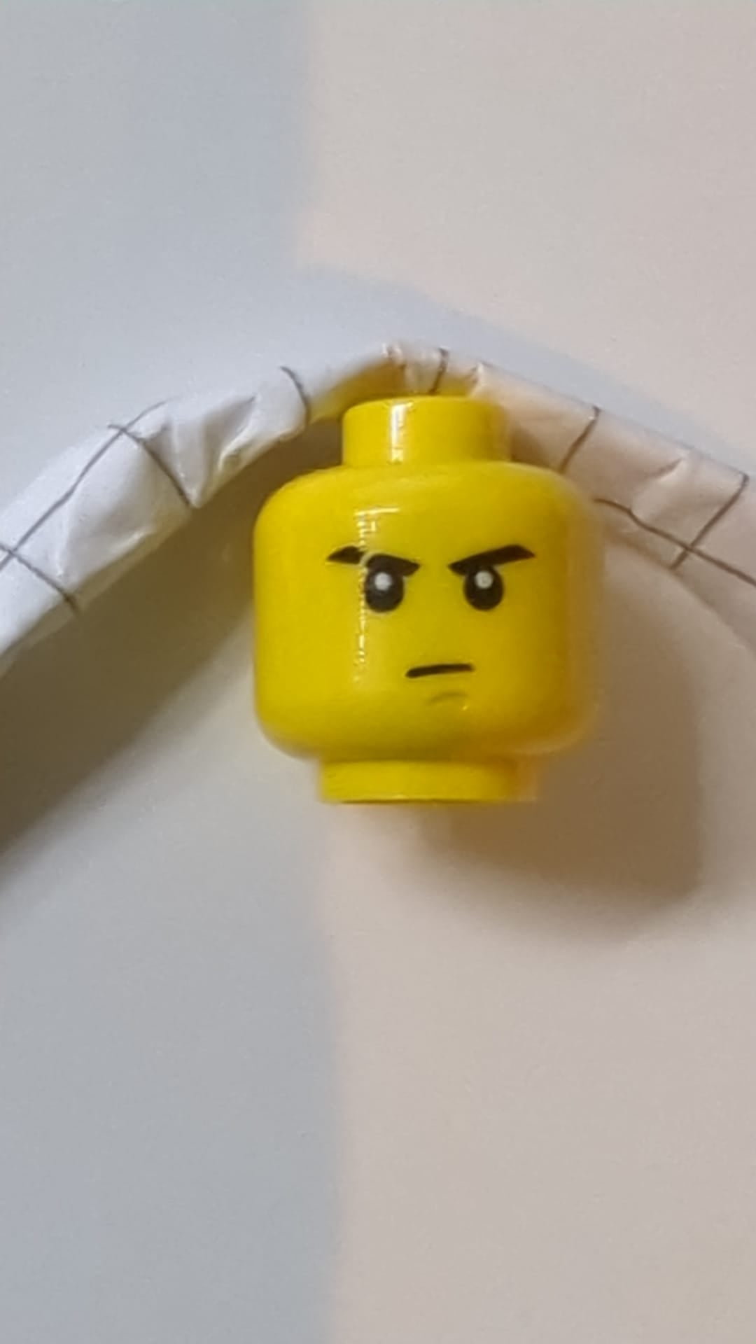 Minifigur, Kopf: schwarze Augenbrauen, rechts: Narbe, mittelgroßes nougatfarbenes Grübchen am Kinn, strenges Muster gelb