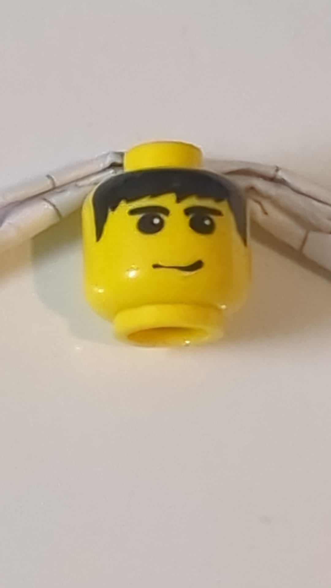 Minifigur, männlicher Kopf, schwarze Haare, Augenbrauen und Grinsenmuster gelb