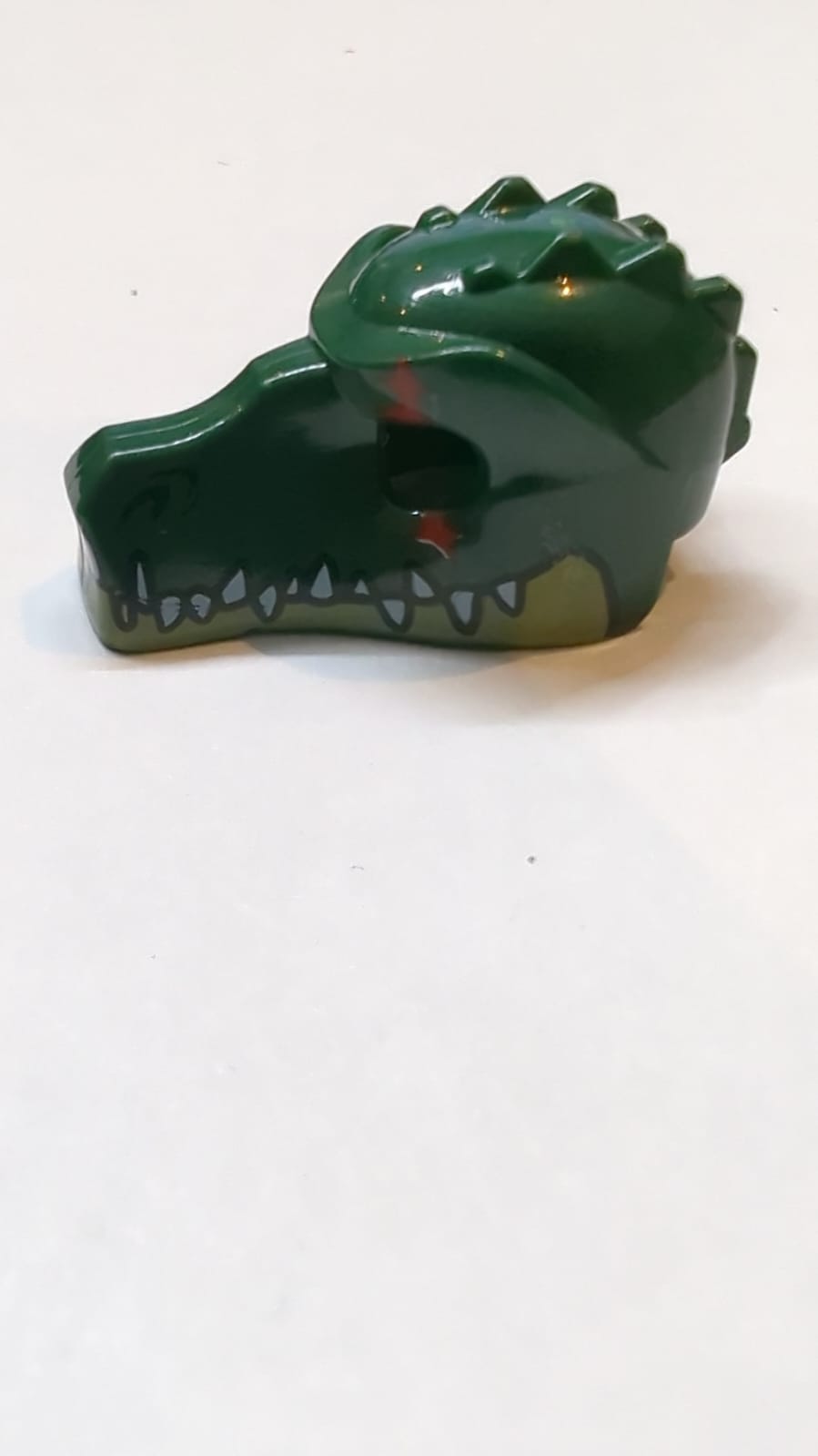 Kopfbedeckung Krokodil mit olivgrünem Unterkiefer, weißen Zähnen und rotem Narbemuster dunkelgrün