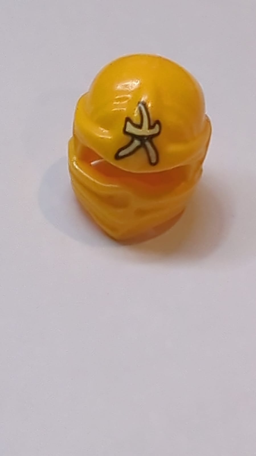 Kopfbedeckung Ninjago Wickeltyp 1 mit leuchtend gelbem Ninjago-Logogramm 'Amber'-Muster hellorange