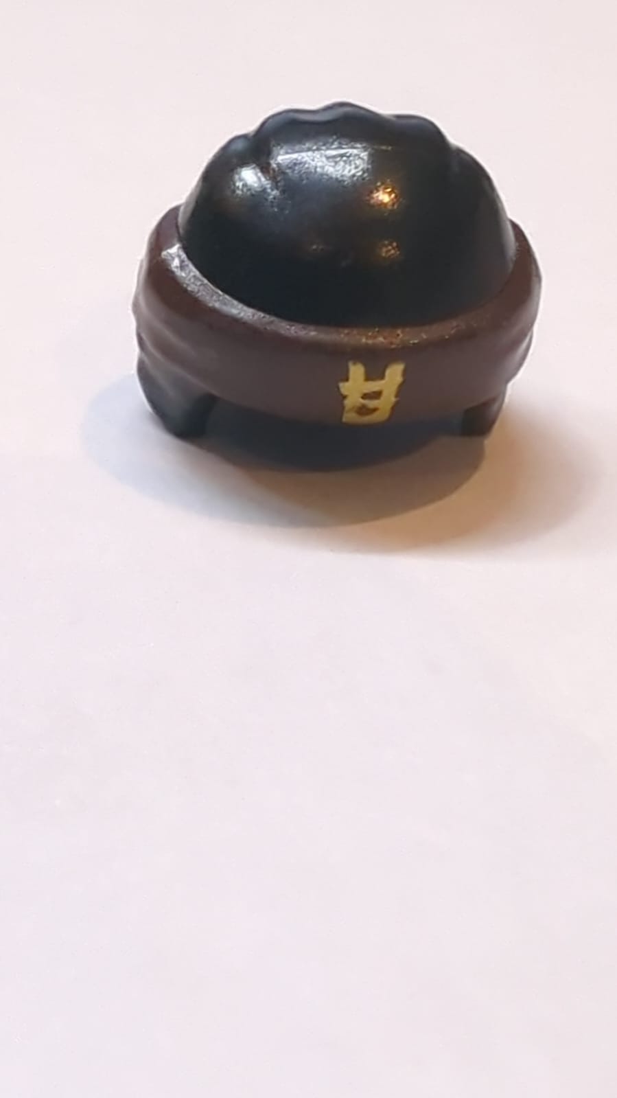 Kopfbedeckung Ninjago Wickeltyp 3 mit geformtem dunkelbraunem Bandana und Knoten sowie aufgedrucktem goldfarbenem Ninjago-Logogramm Buchstabe E Muster schwarz