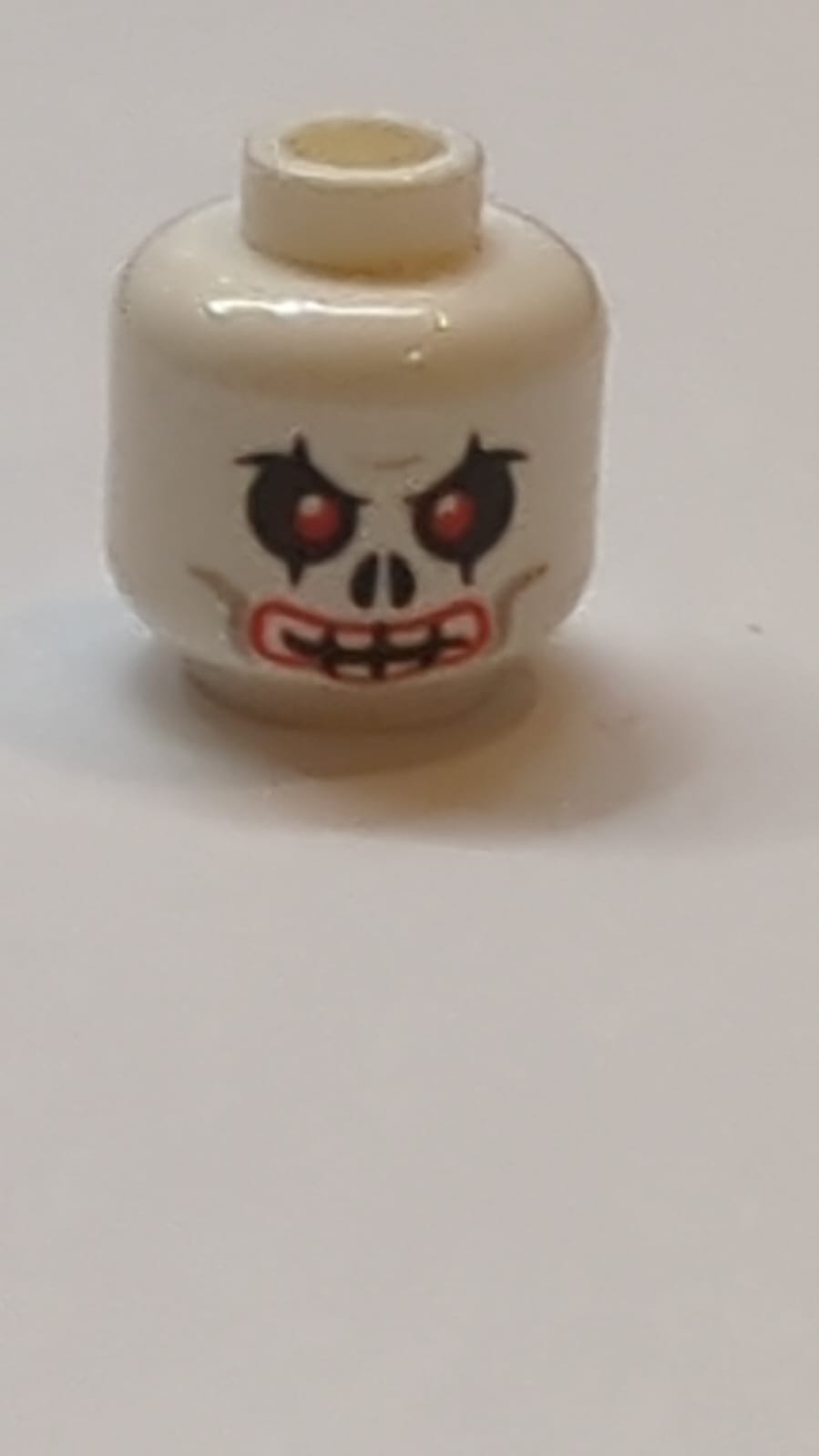 Kopf Schädel Rote Augen und Mundkontur, Hellbläulich-graue Wangenlinien, Zusammengezogene Stirn, Böses Grinsen Muster