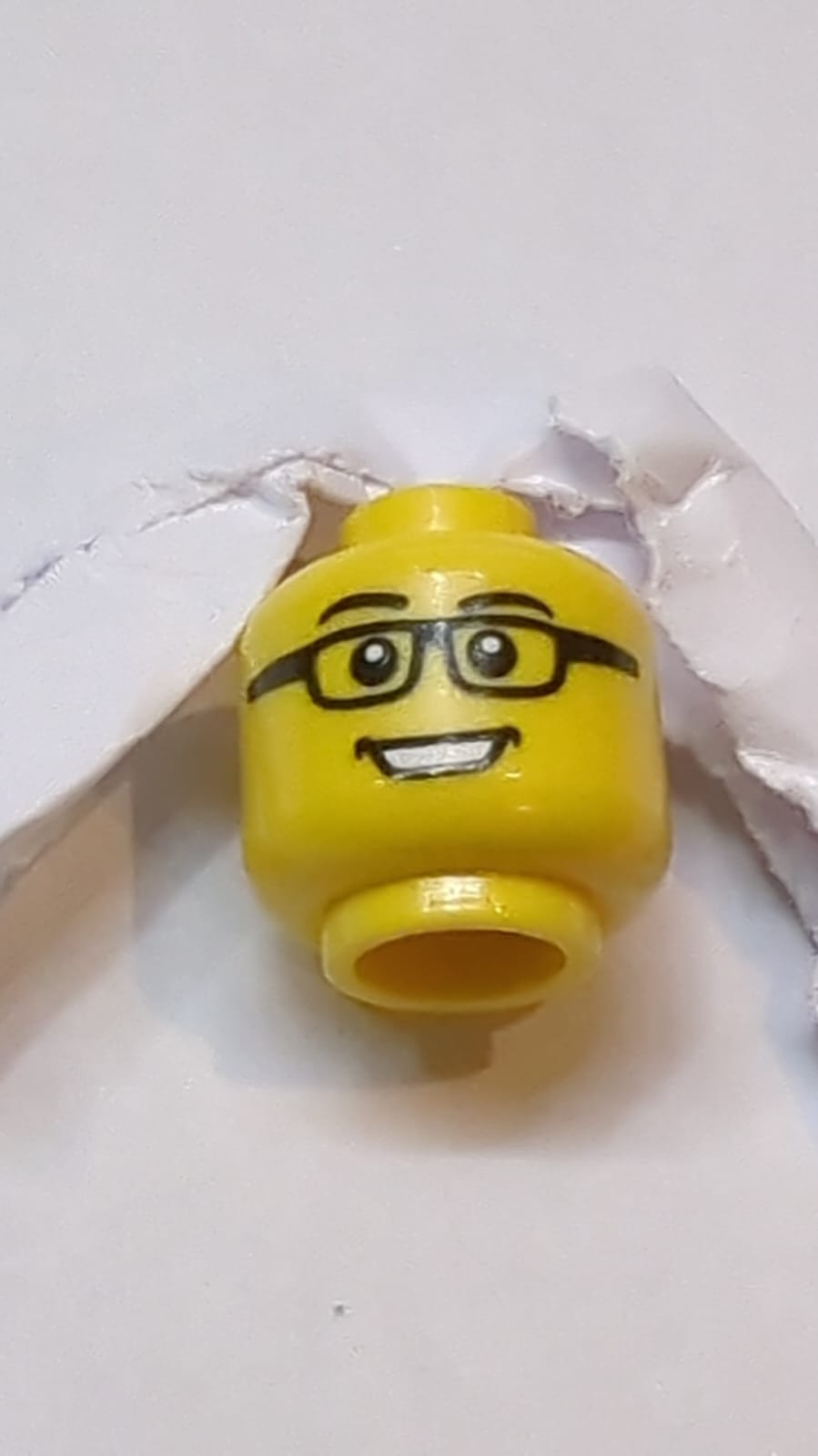 Kopf mit schwarzen Augenbrauen und Brille, offener Mund mit Zahnreihen lächelnd