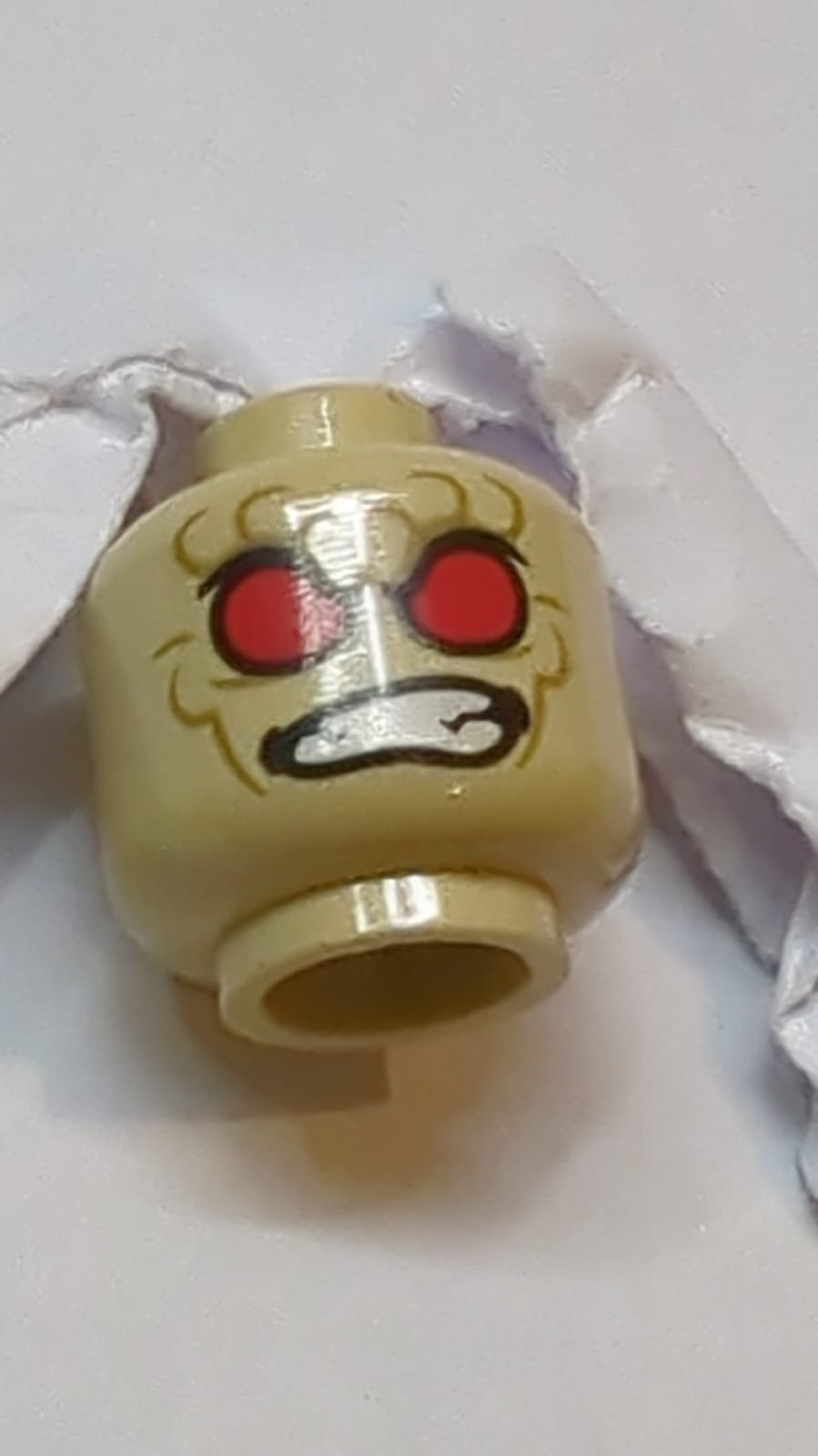 Kopf mit zwei Seiten eines Außerirdischen mit roten Augen, dunklen Falten, wütend zusammengebissenen Zähnen / Muster eines bösen Lächelns