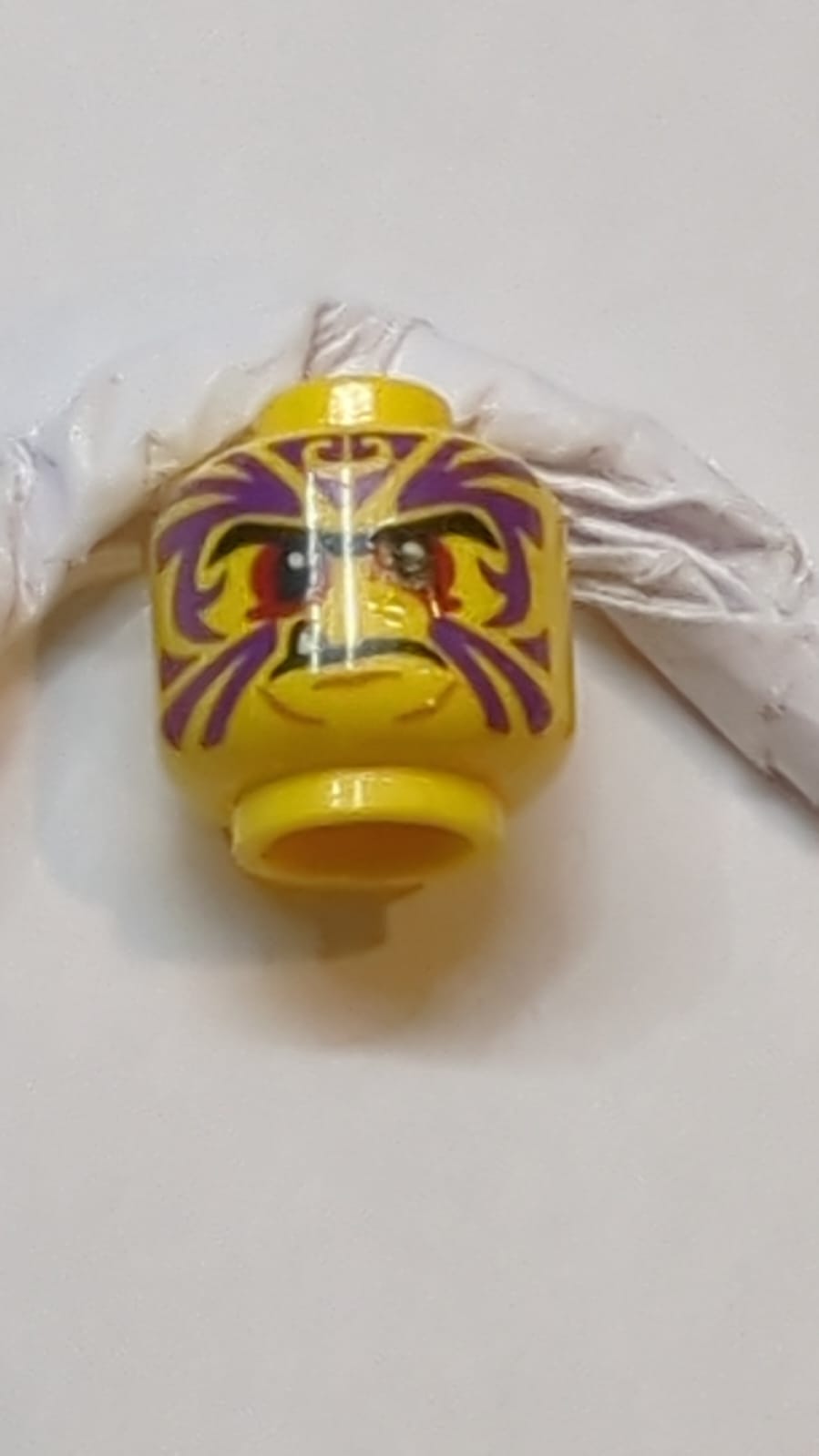 Kopf schwarz, Augenbrauen schwarz, rote Augen, lila Tätowierung, Fangmuster