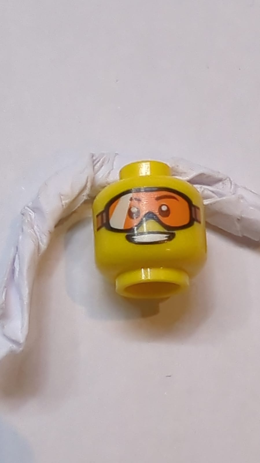 Kopfform mit orangefarbenen Schutzbrillen, offener Mund mit Zahnzeichnung