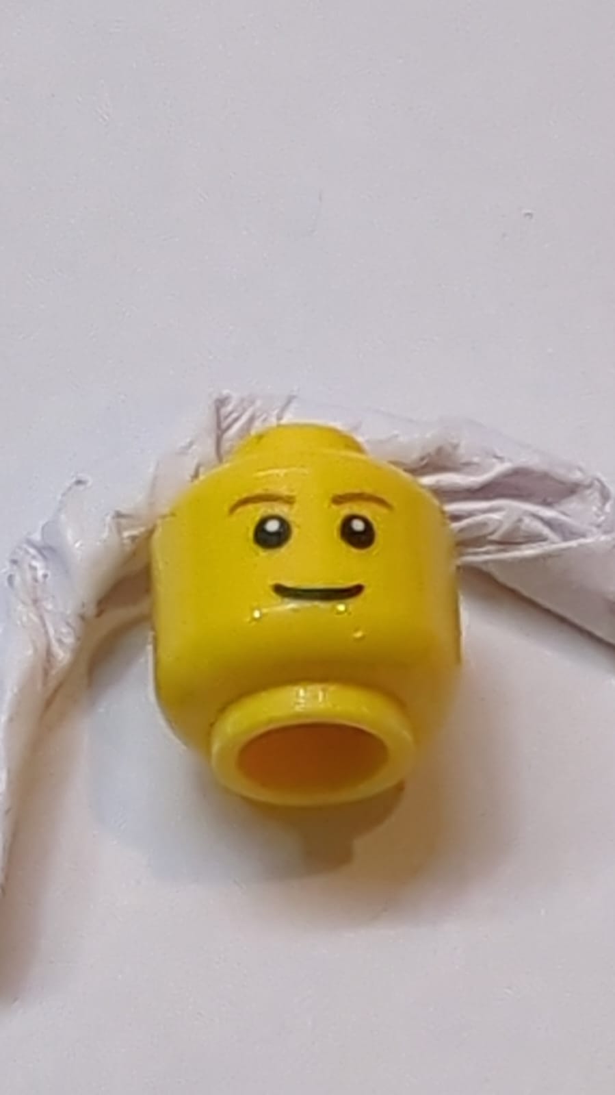 Kopf braune Augenbrauen, schmales Grinsen, schwarze Augen mit weißer Pupillenmuster