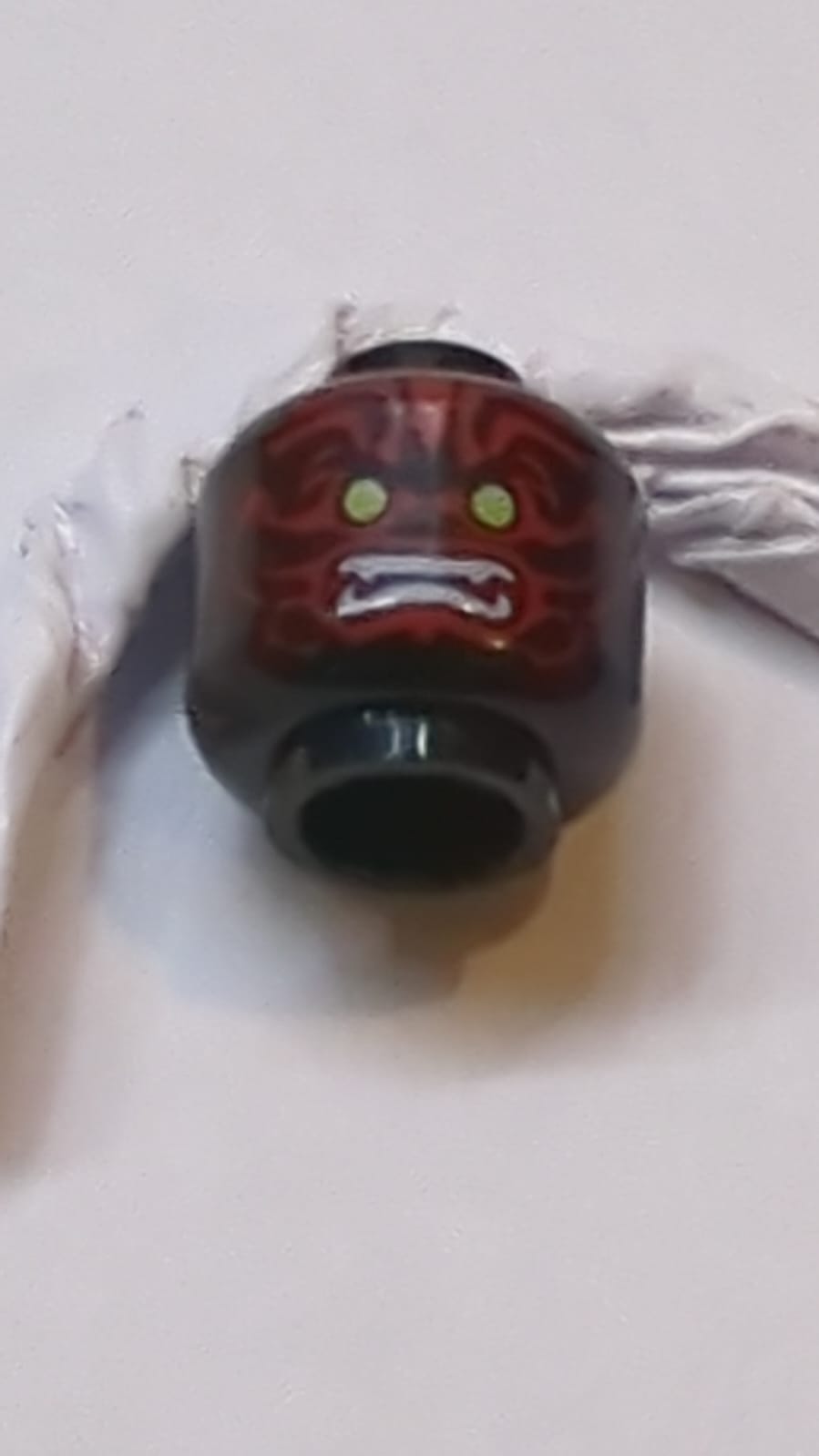 Kopf-Alien mit limonengrünen Augen, weißen Fangzähnen und dunkelroten Gesichtsmustern