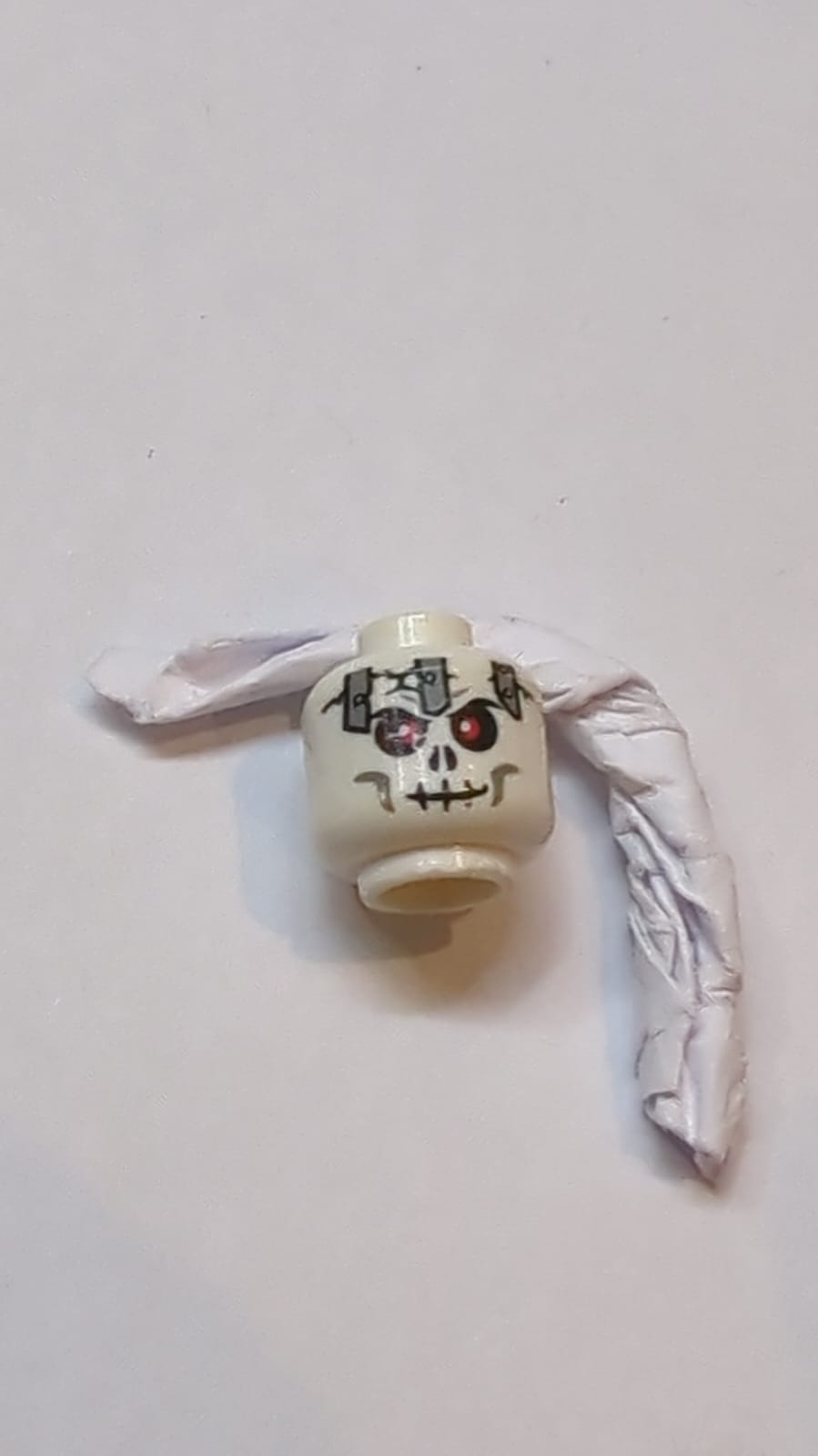 Kopf Schädel mit roten Augen, schwarzen Rissen, hellblau-grauen Metallplatten und Wangenlinien, Muster eines bösen Grinsens