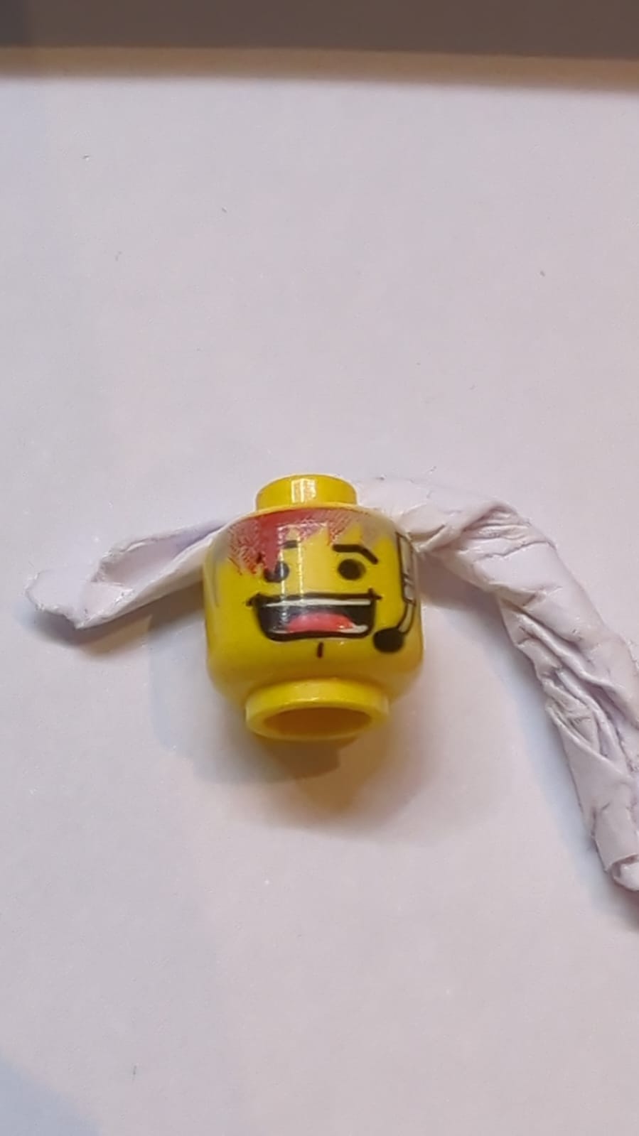 Kopf Schwarze Augenbrauen, hellgraues und rotes Haar, Headset, Kinngrübchen, großes offenes Lächeln mit sichtbaren Zähnen und Zungenmuster