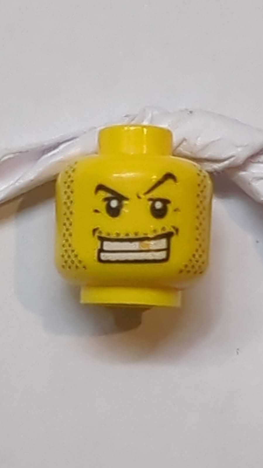 Kopf Männlich, schwarze dünne Augenbrauen, obere Augenlider, Schnurrbart- und Kotelettenstoppel, weit geöffneter Mund mit Lächeln, Zähne sichtbar und Goldzahnmuster