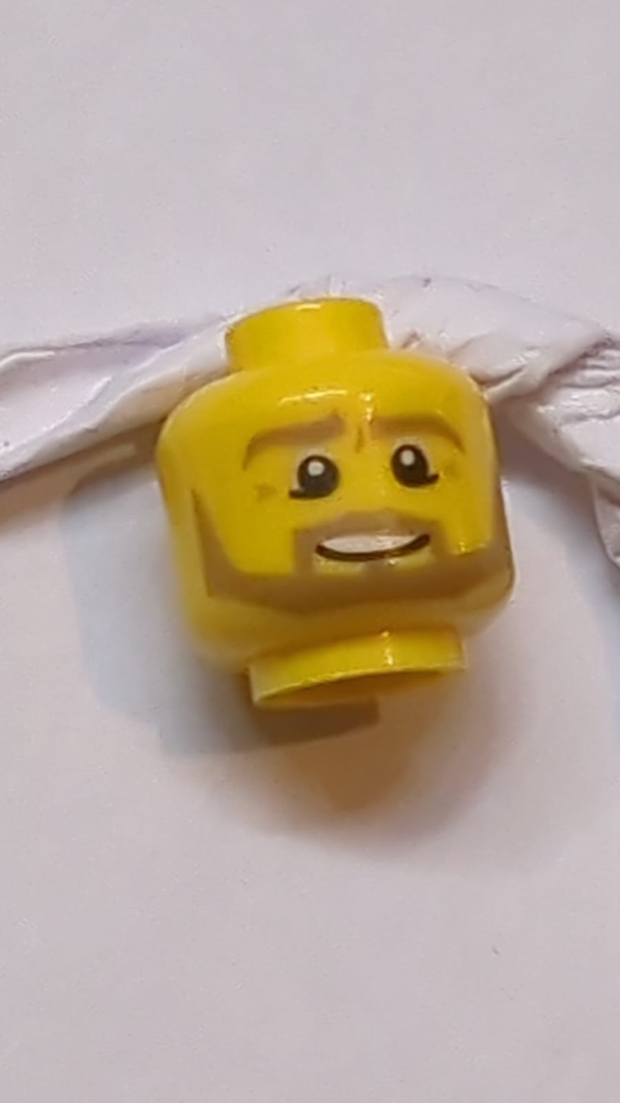 Kopf Dunkelbraune Augenbrauen, Schnurrbart und kantiger Bart, untere Augenlider, mittlere Nougat-Falten, schiefer offener Mundlächeln mit Zahnstruktur