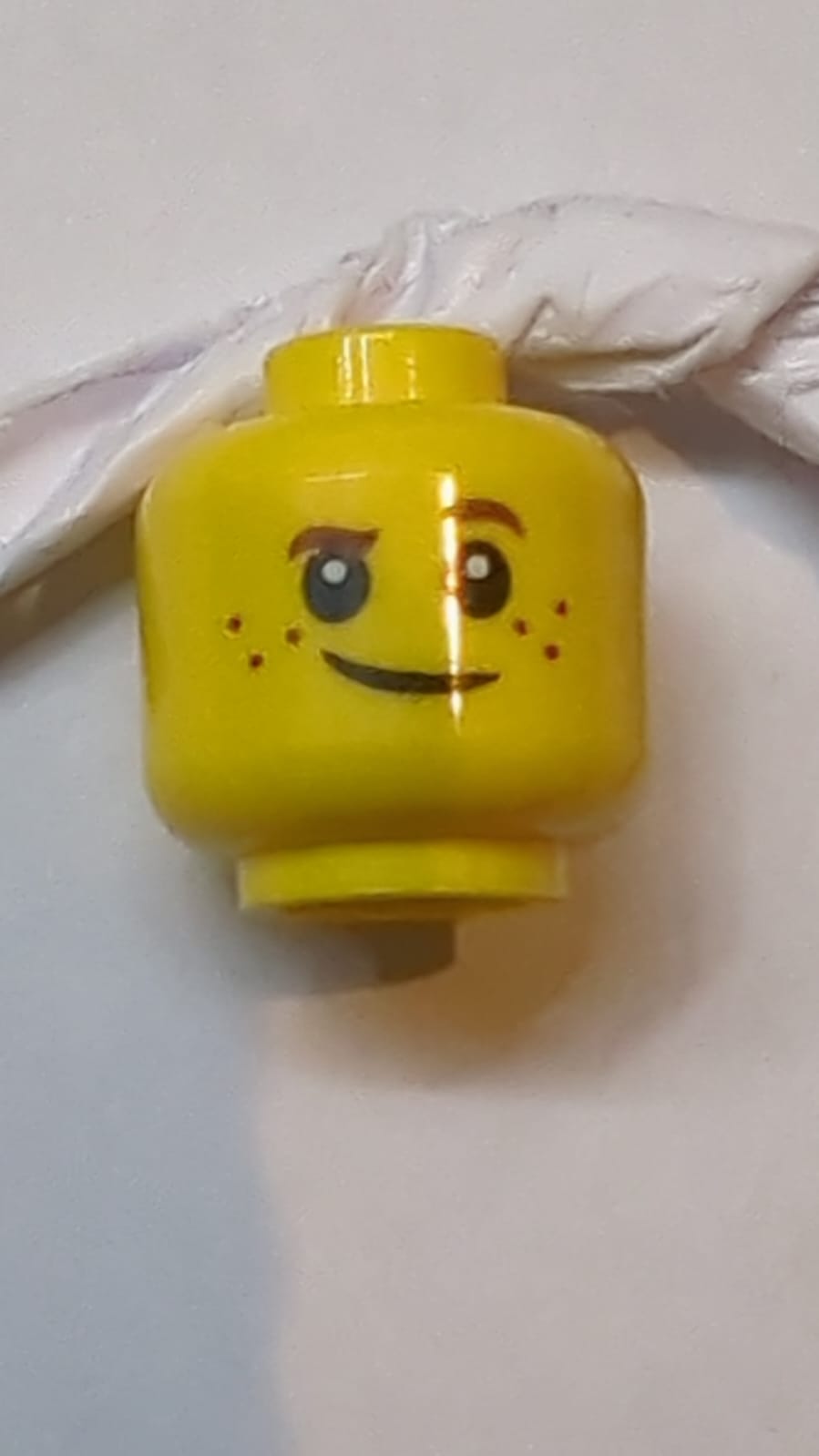 Kopf Kind braune Augenbrauen, linke Augenbraue hochgezogen, Sommersprossen, weiße Pupillen, schiefes Lächeln Muster