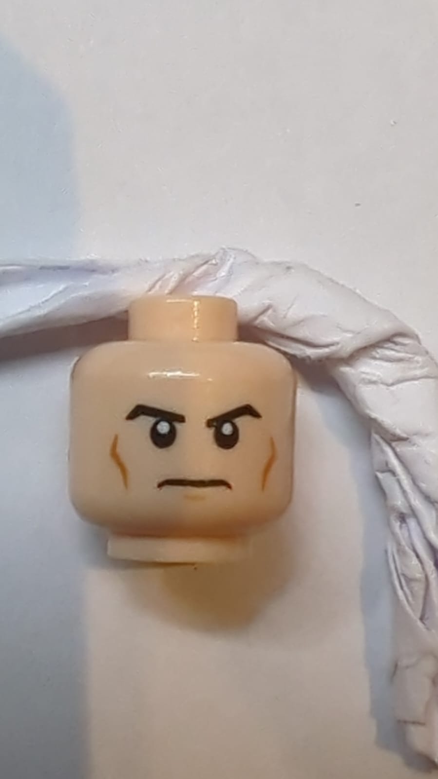 Kopf Schwarze, schräg geformte Augenbrauen, mittlere Nougat-Wangenlinien und Kinngrübchen, strenger Ausdruck