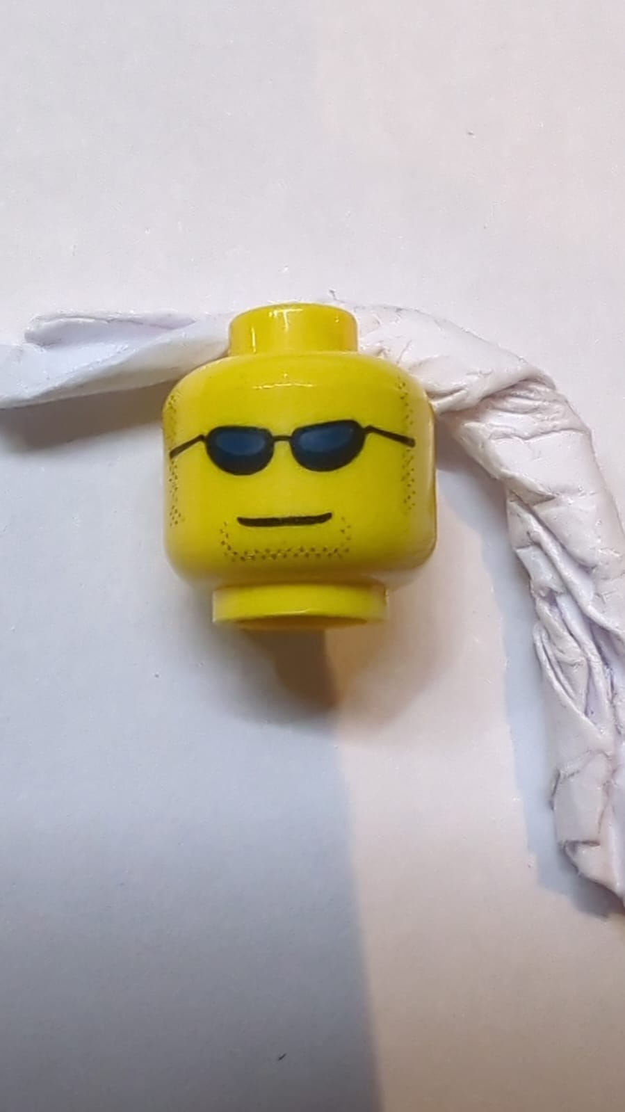 Kopf Schwarze Sonnenbrille mit dunkelblauen Gläsern, dunkle Koteletten und Kinnbartstoppeln, grinendes Muster