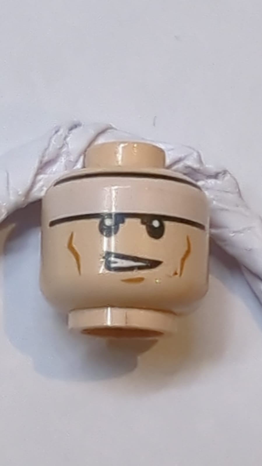 Kopf Beidseitiges weißes Stirnband, mittlere Nougat-Wangenlinien und Kinngrübchen, Stirnrunzeln / schiefe offene Mundstellung mit Zahnmuster