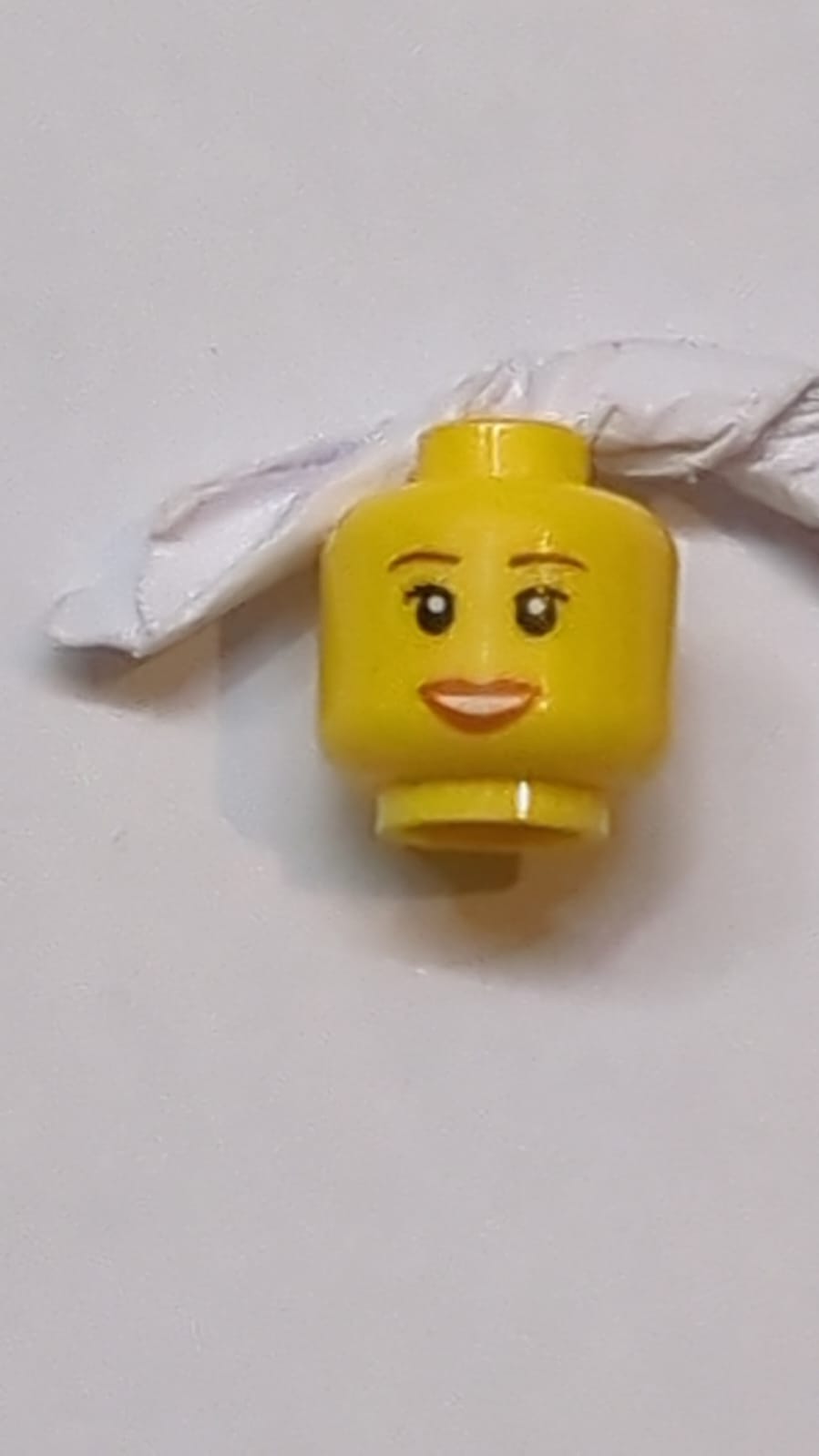 Kopf Weibliche rötlich-braune Augenbrauen, schwarze Wimpern, dunkelorange Lippen, offenes Lächeln mit Zahnreihe