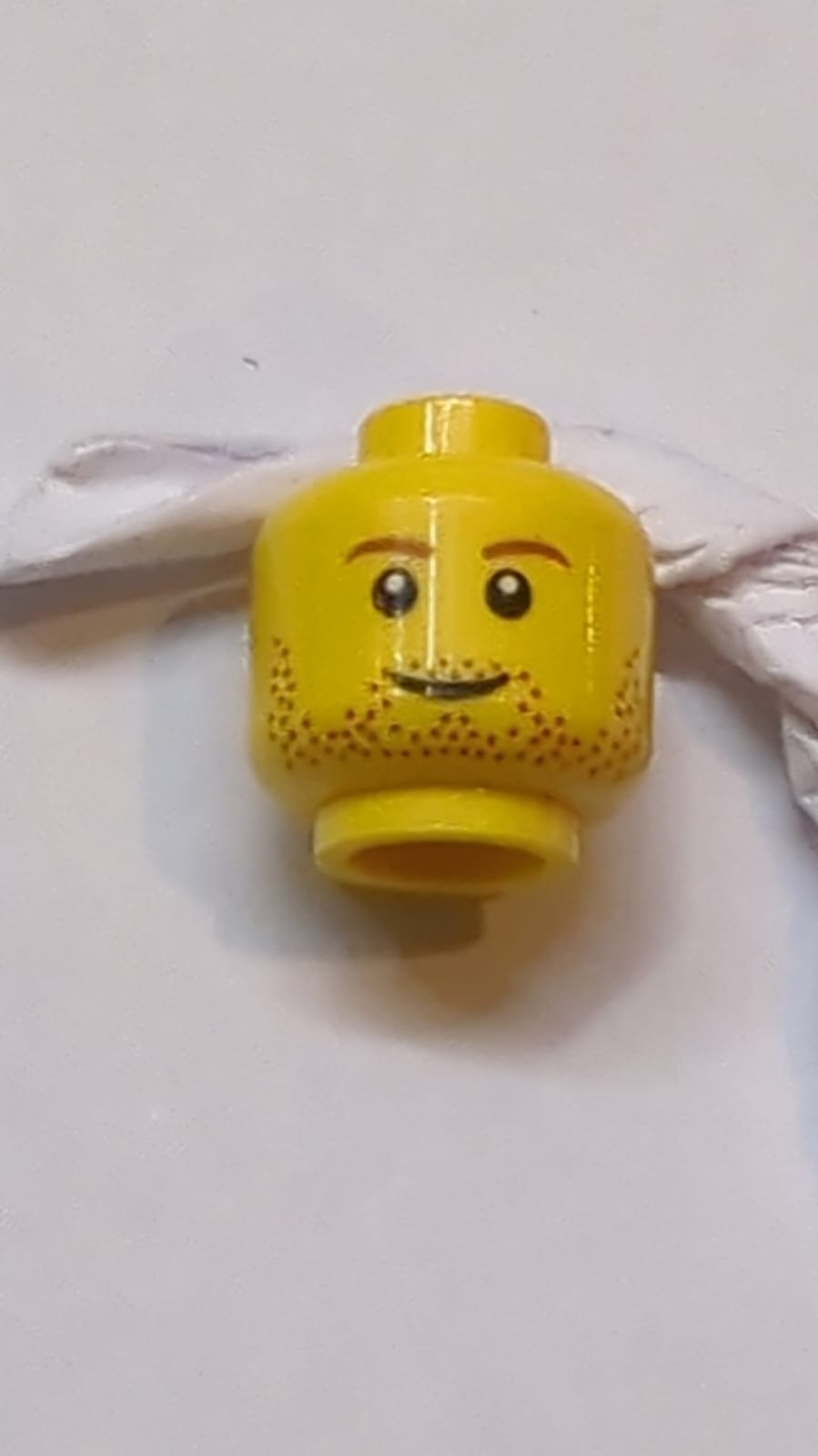 Kopf Beidseitig rötlich-braune Augenbrauen und Bartstoppeln, grinsendes / besorgt welliges Mundmuster