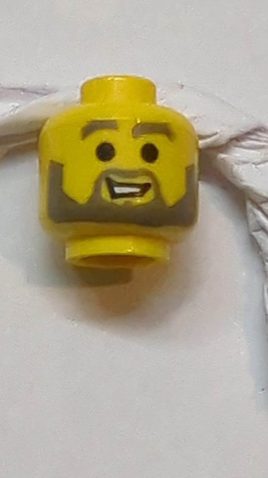 Kopf Dunkelgraue Augenbrauen, Schnurrbart und Bart, offenes Mundlächeln mit Zahn-Muster