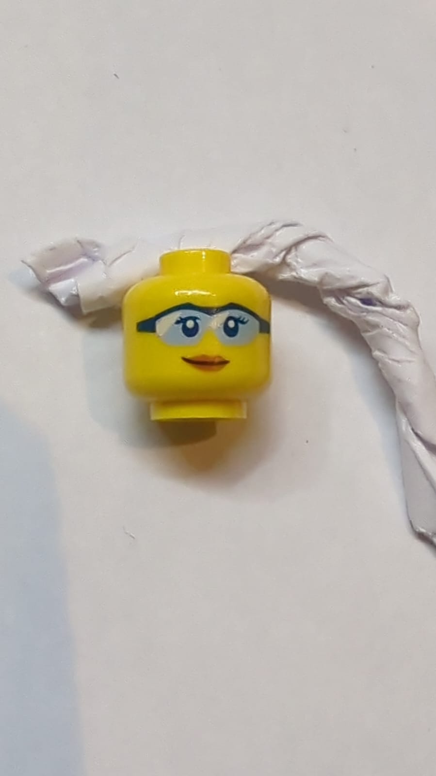 Kopf Weibliche dunkelblaue Augen und Wimpern, Schutzbrille mit hellblauen Gläsern und weißen Reflexionen, dunkelorangefarbene Lippen, leicht schiefer Grin-Muster