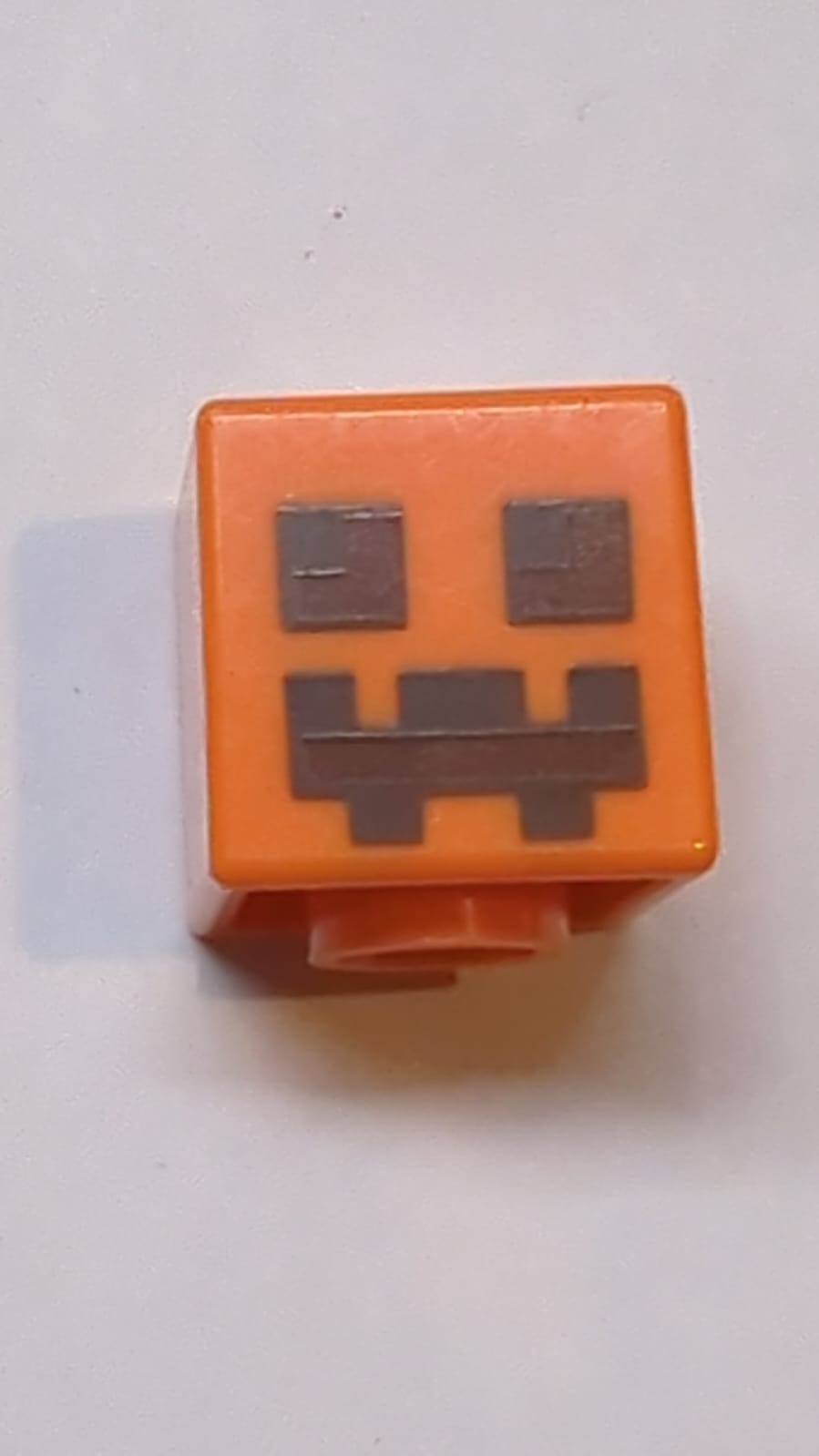 Kopf Modifizierter Würfel mit pixeligen dunkelbraunen und rötlich-braunen Augen- und Mundmustern (Minecraft Kürbis Jack O' Lantern / Schneegolem)