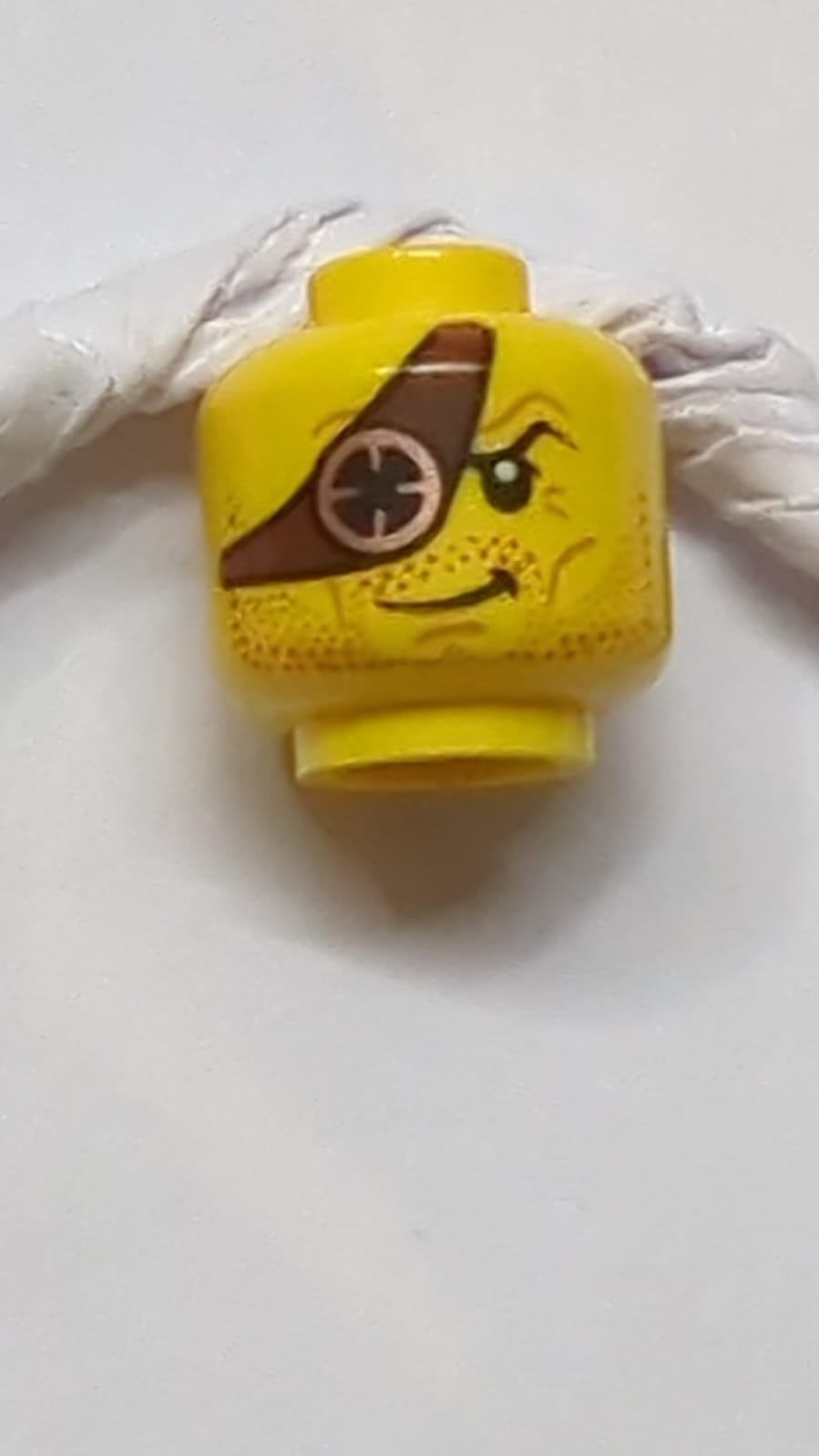 Kopf Bartstoppeln Dunkelrot, rötlich-braune Augenklappe mit Kupfer-Okularmuster gelb