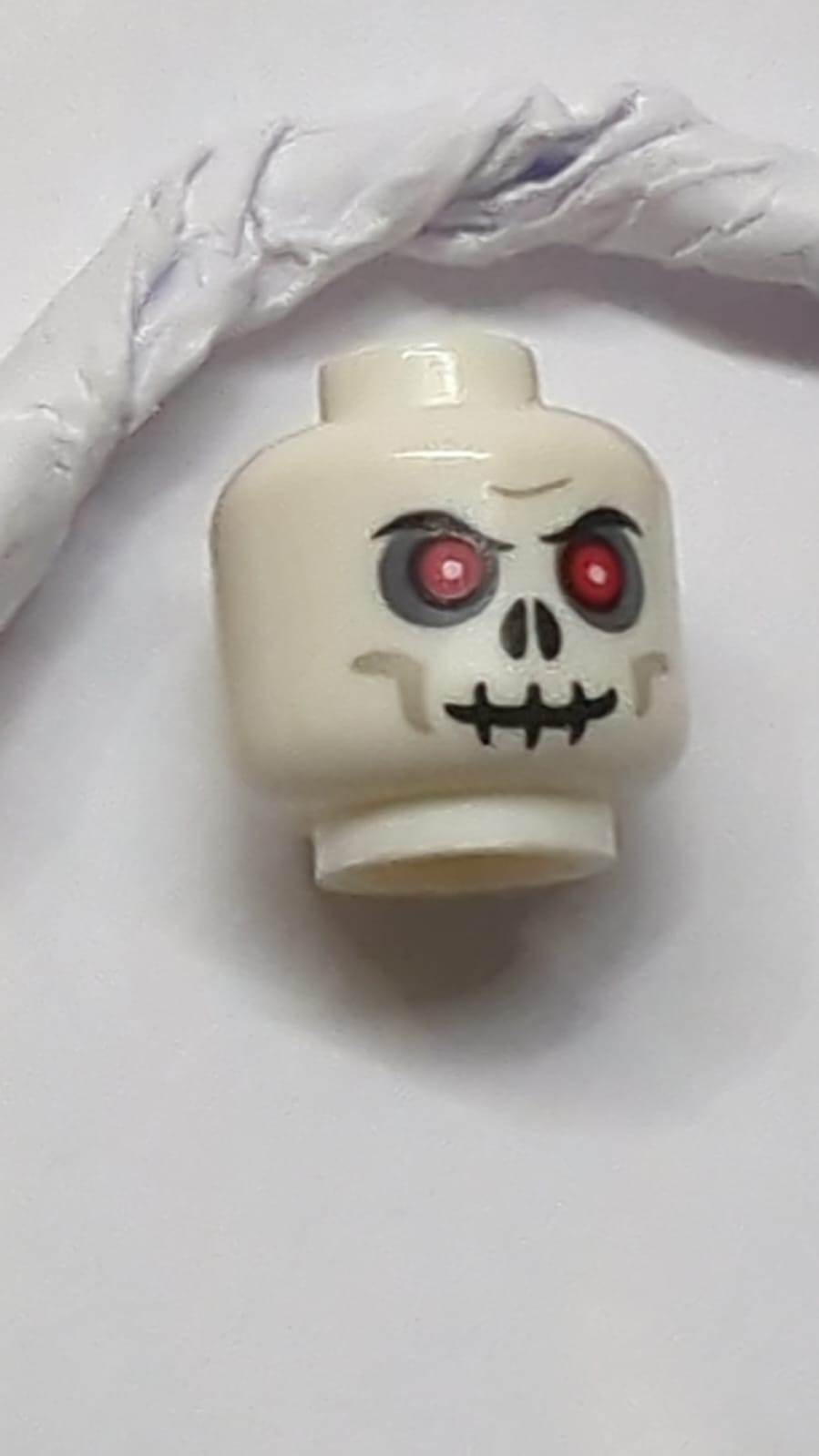 Kopf-Schädel mit roten Augen, dunkelblau-grauer Lidschatten, hellblau-graue Wangenlinien, schwarzer Mund und Nasenlöcher, zusammengezogene Augenbrauen, bösartiges Grinsen Muster weiss