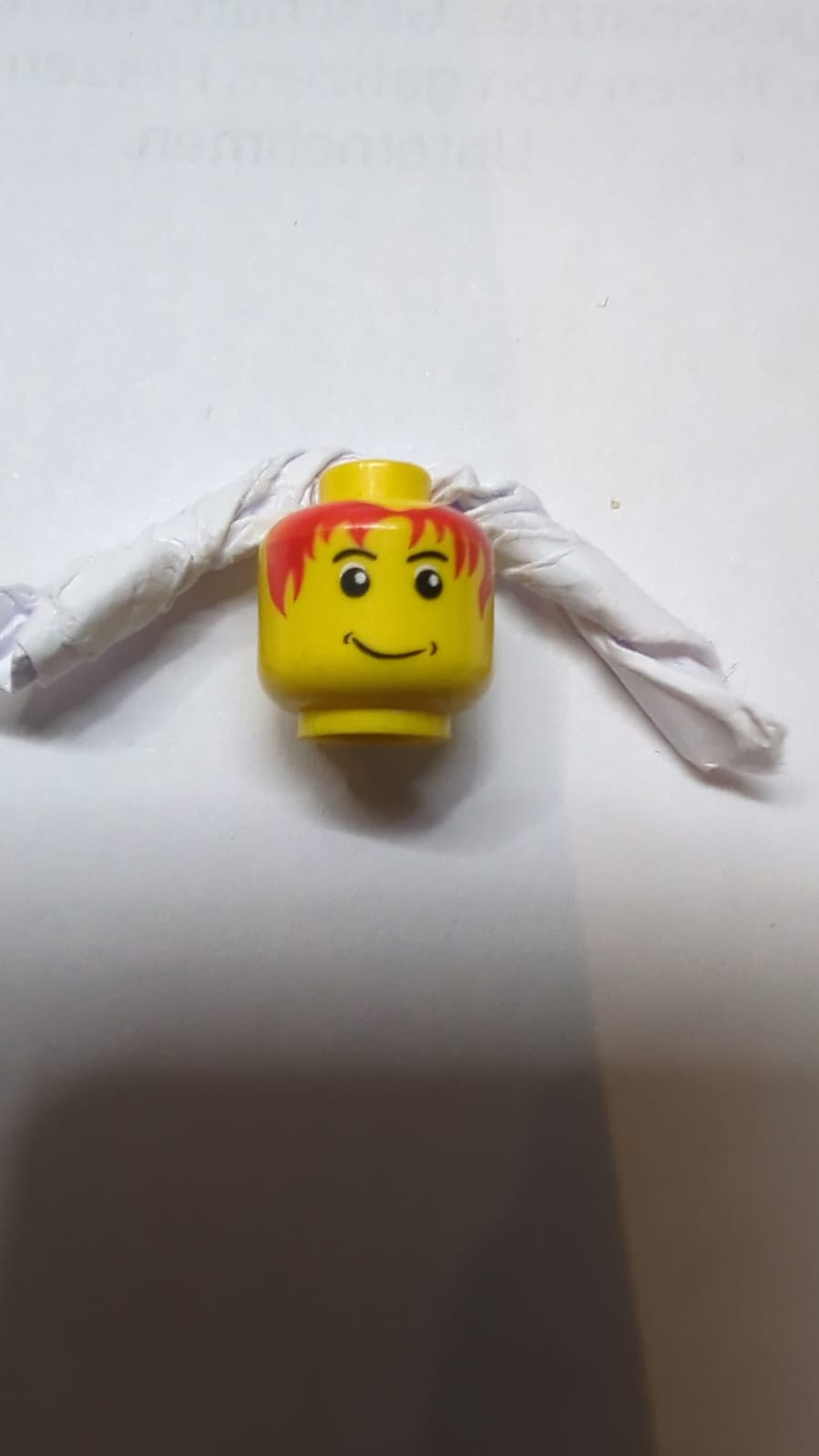 Kopf mit schwarzen Augenbrauen, unordentliches rotes Haar, schiefes Grinsen mit Grübchenmuster gelb