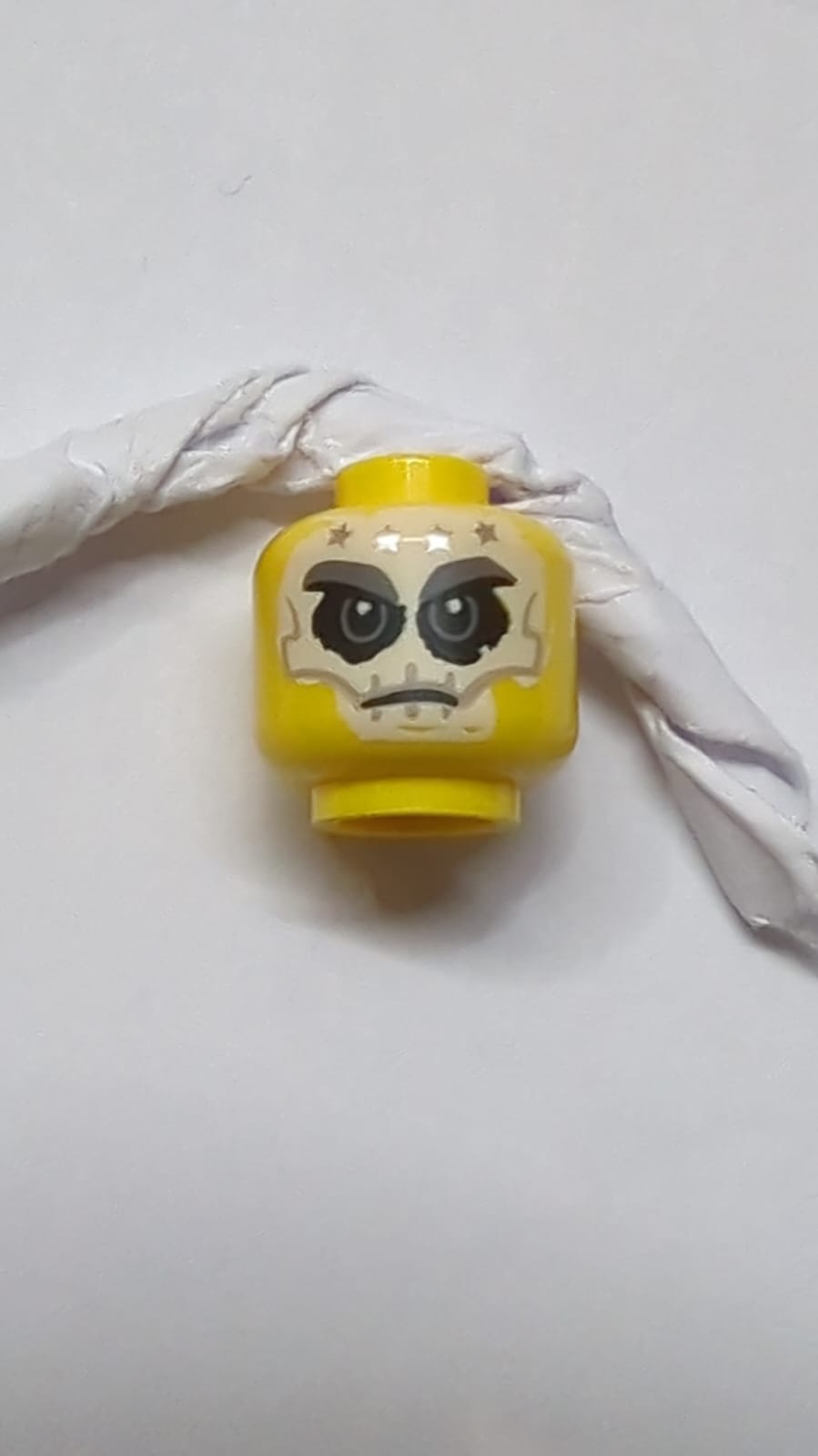 Vollgesicht-Schädel-Tattoo auf dem Kopf, 4 silberne Sterne als Muster auf der Stirn gelb