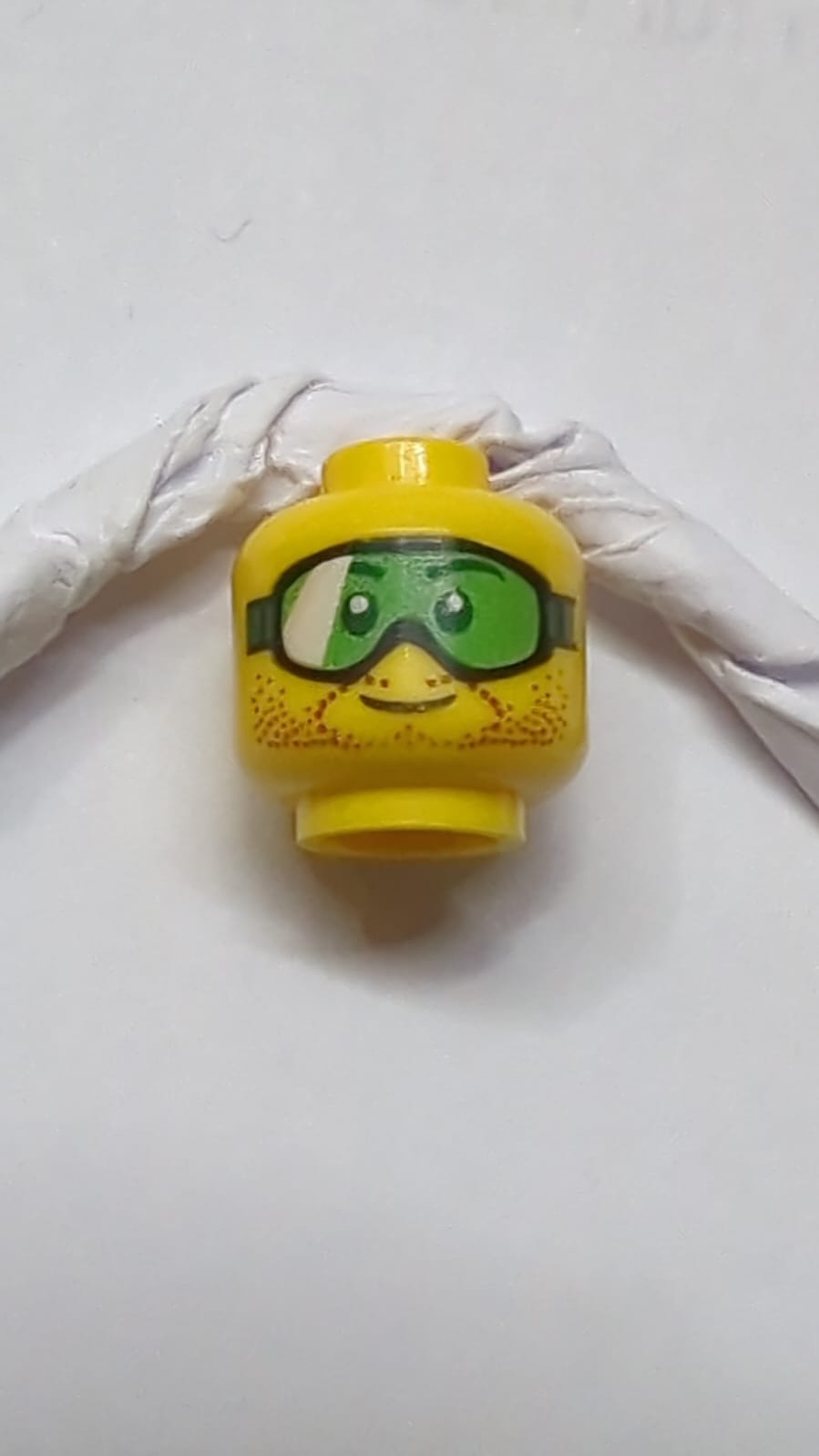 Kopf mit grüner Schutzbrille und braunem Stoppelmuster gelb