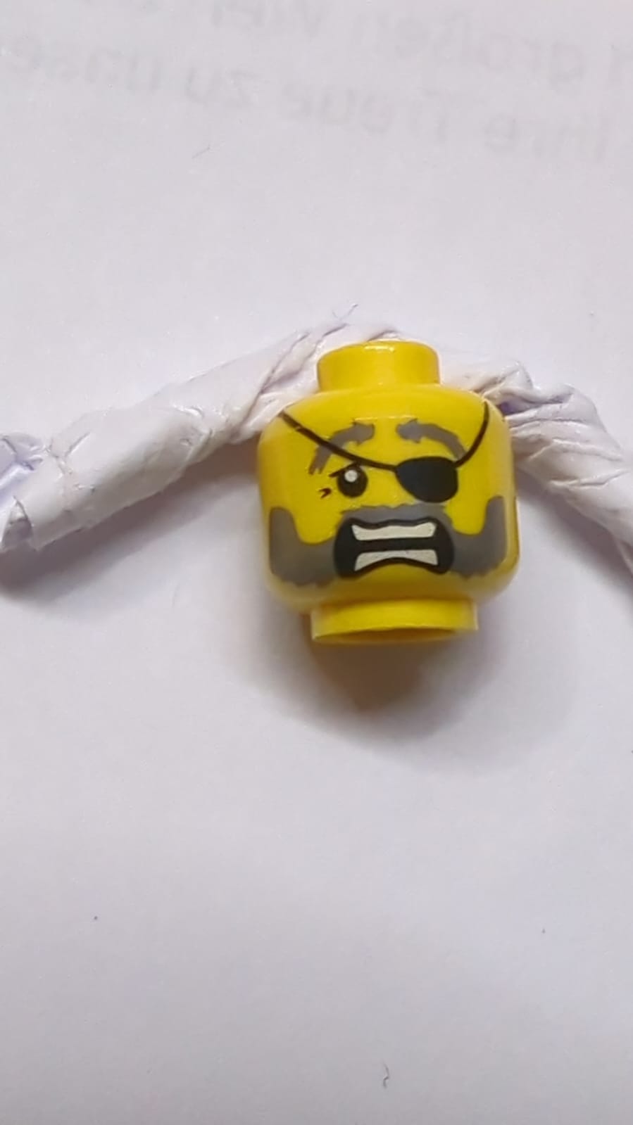 Kopf mit doppelseitigen, dunkelblau-grauen buschigen Augenbrauen, Schnurrbart und Bart, Oberlid, schwarzes Augenklappe, streng mit Kinngrübchen / erschrocken offenem Mund mit voneinander getrennten Zähnen