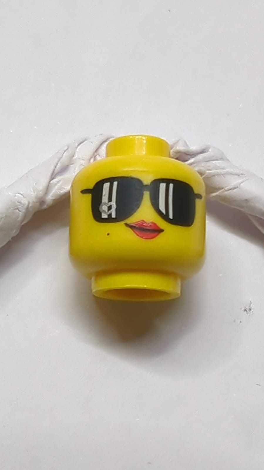 Kopf einer Frau, schwarze Sonnenbrille, rote Lippen, Schönheitsfleck, Schmunzelmuster gelb