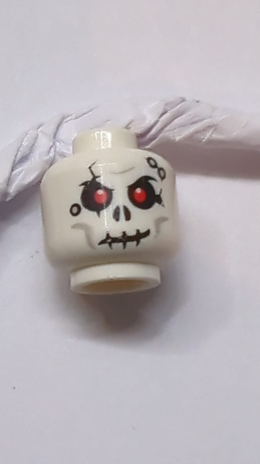 Kopfschädel mit Rissen und Löchern, Muster mit roten Augen weiß